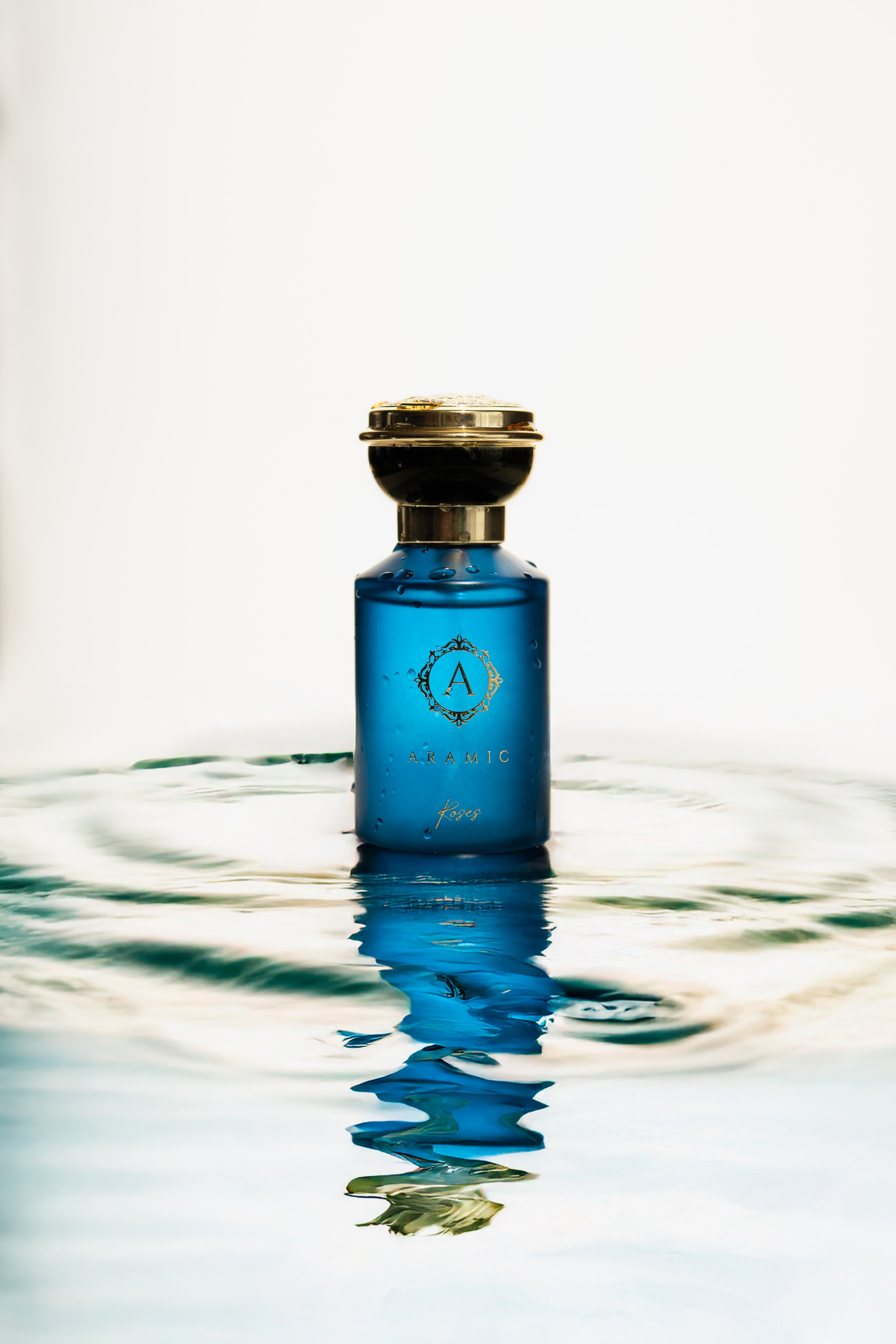 Blue perfume bottle floating on water surface — creative reflective perfume photography.