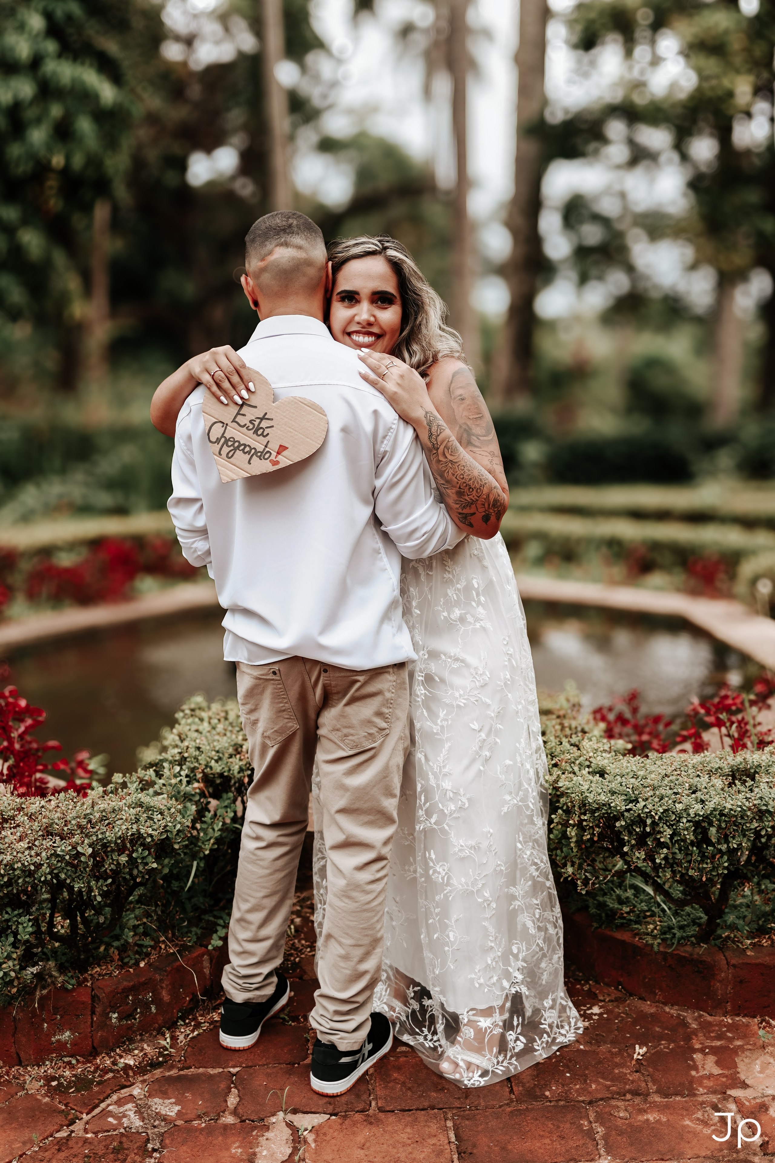 Casal trocando carinho em jardim florido, registrado por fotógrafo de ensaio romântico em Pederneiras.