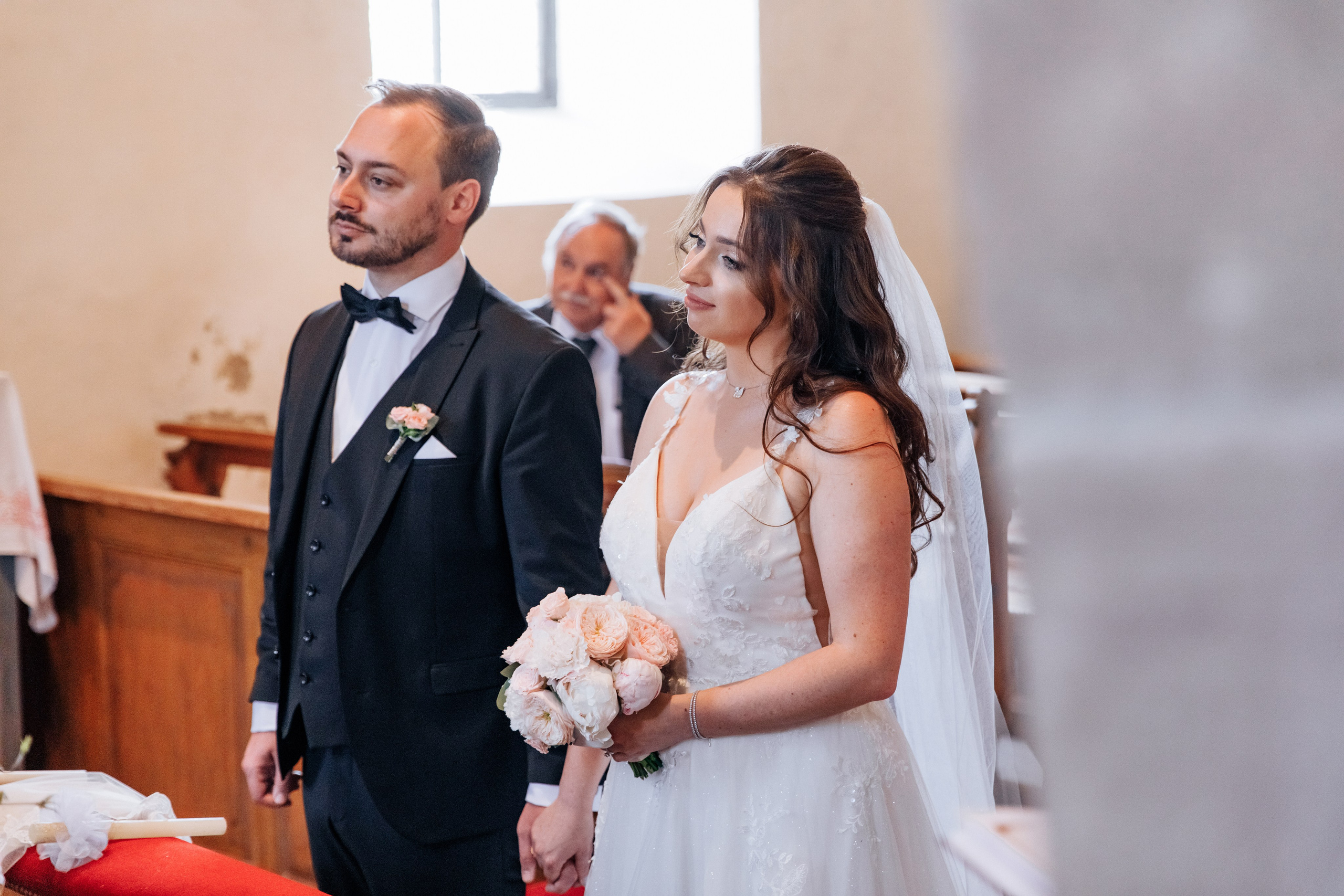 Die Braut und der Bräutigam hören aufmerksam dem Priester während der Zeremonie zu.