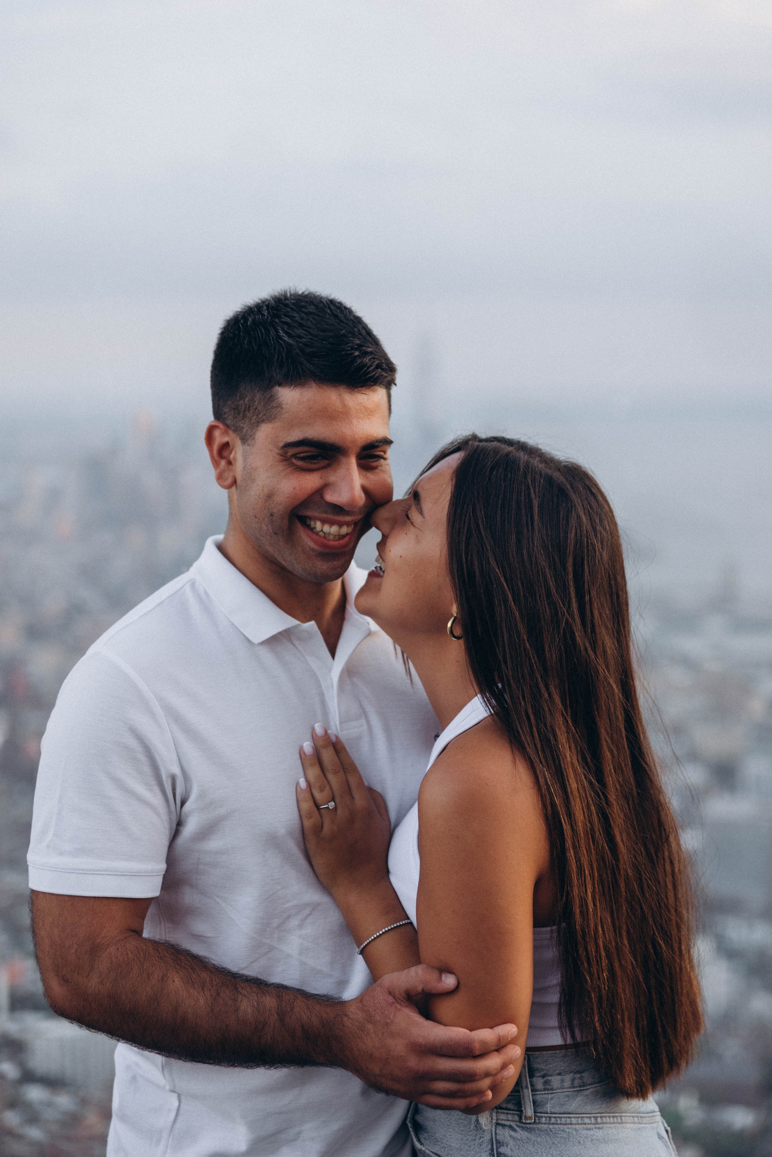 Proposal moment under Manhattan Bridge at golden hour.