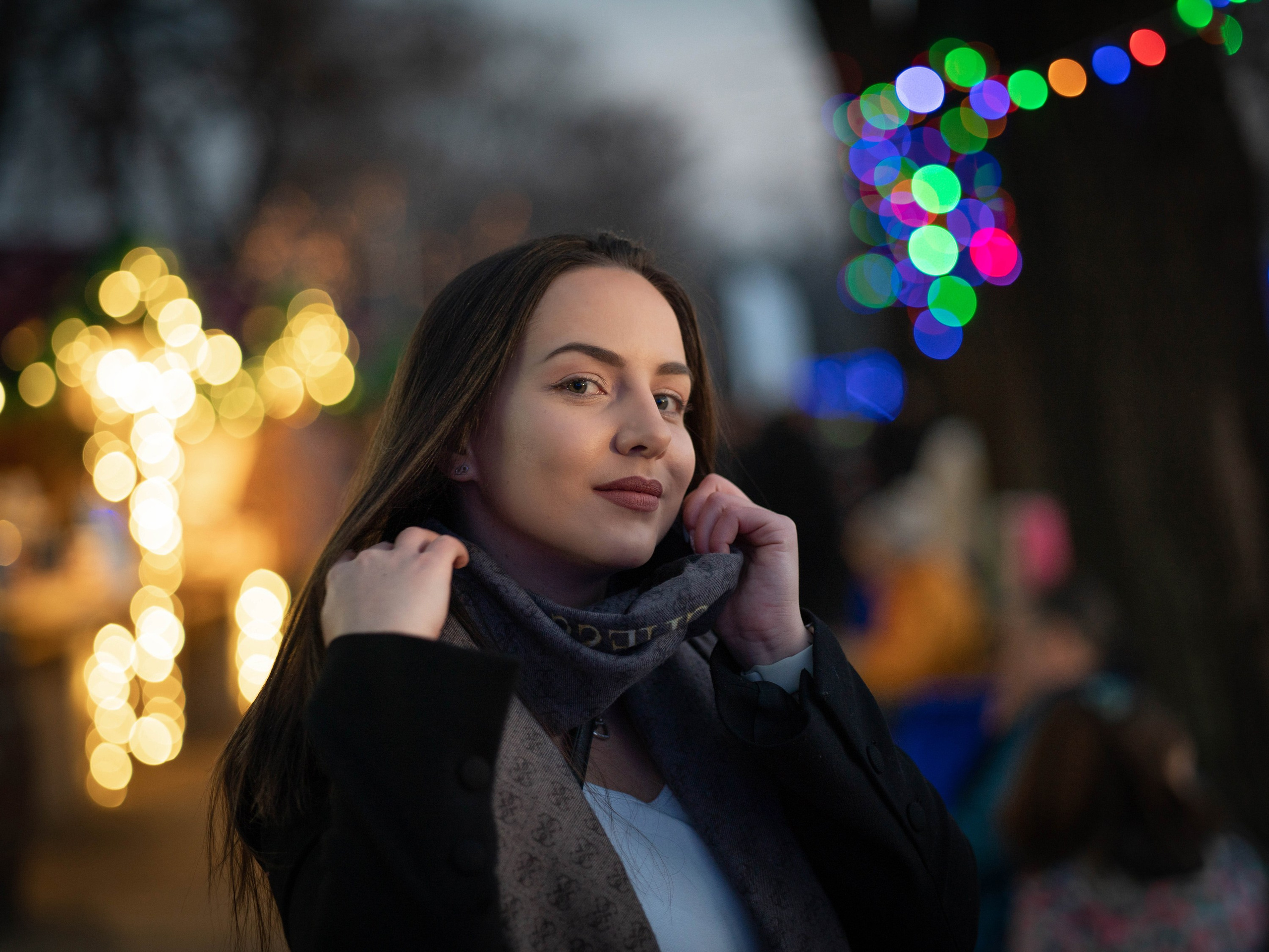 Evening street portrait of a woman in city lights, street portrait photography