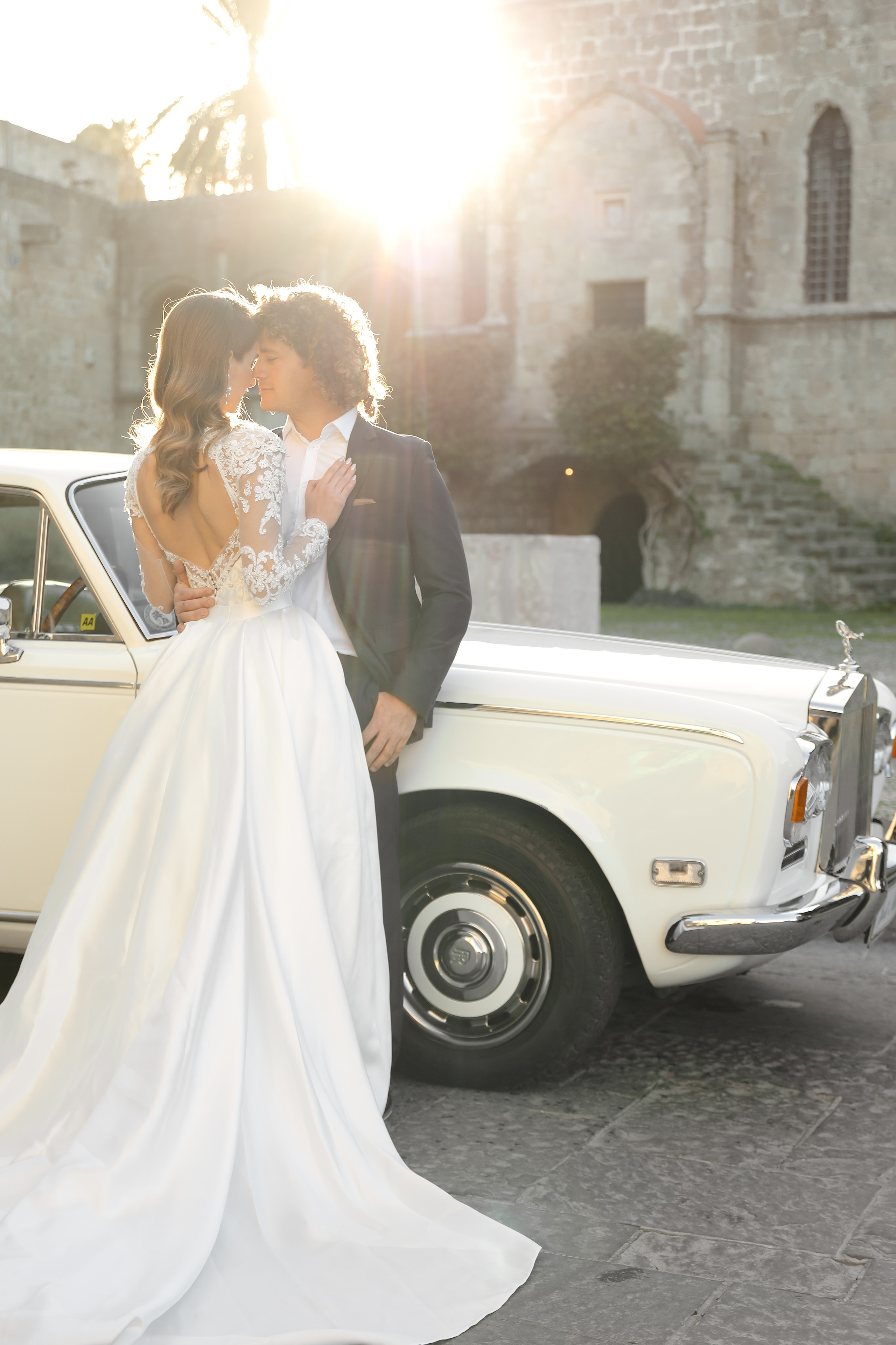 A bride and groom next to Rolls Royce in old town of Rhodes island, Greece