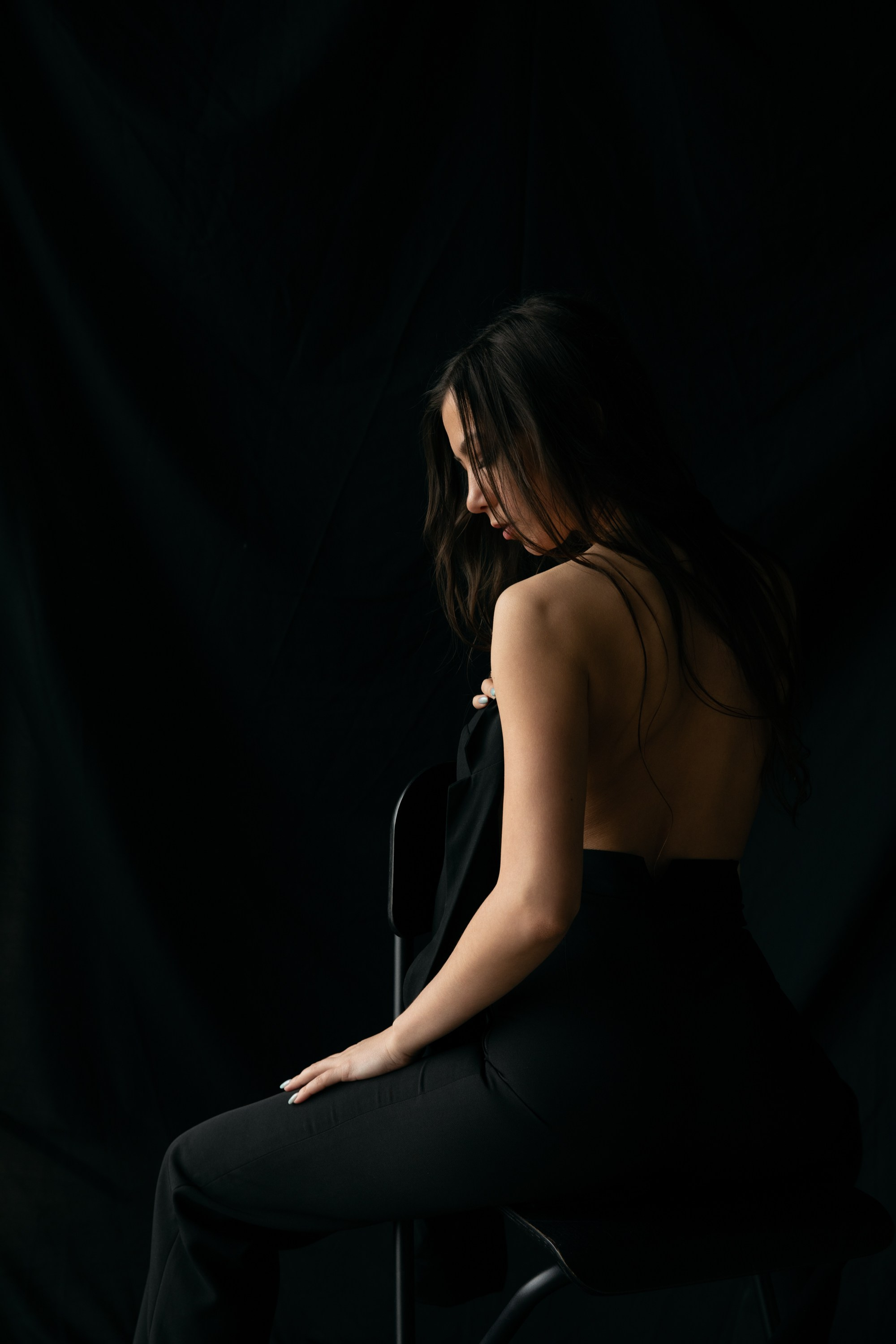 Künstlerische Silhouette einer sitzenden Frau in schwarzer Hose