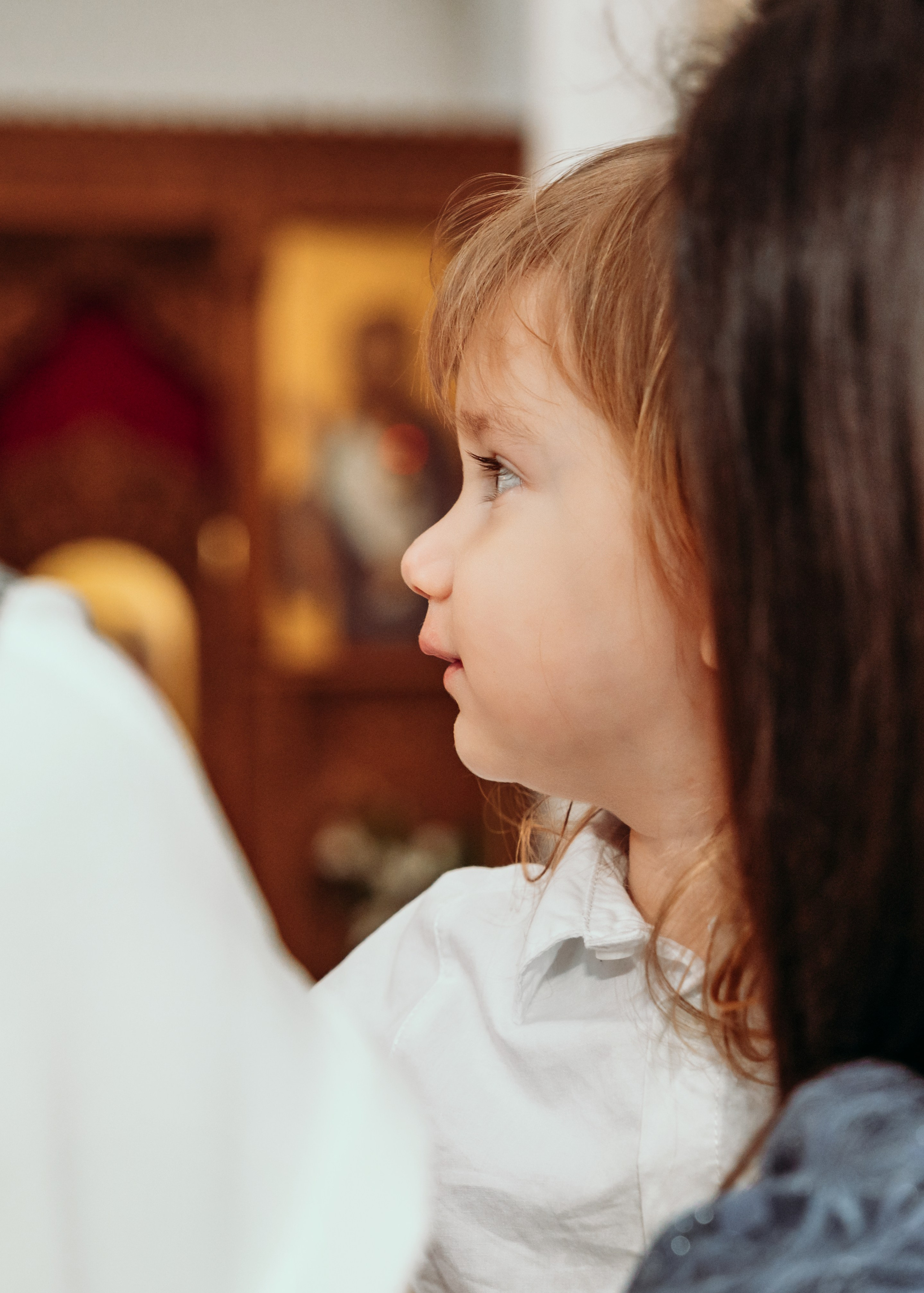 Kum drži bebu tokom krštenja u Beogradu