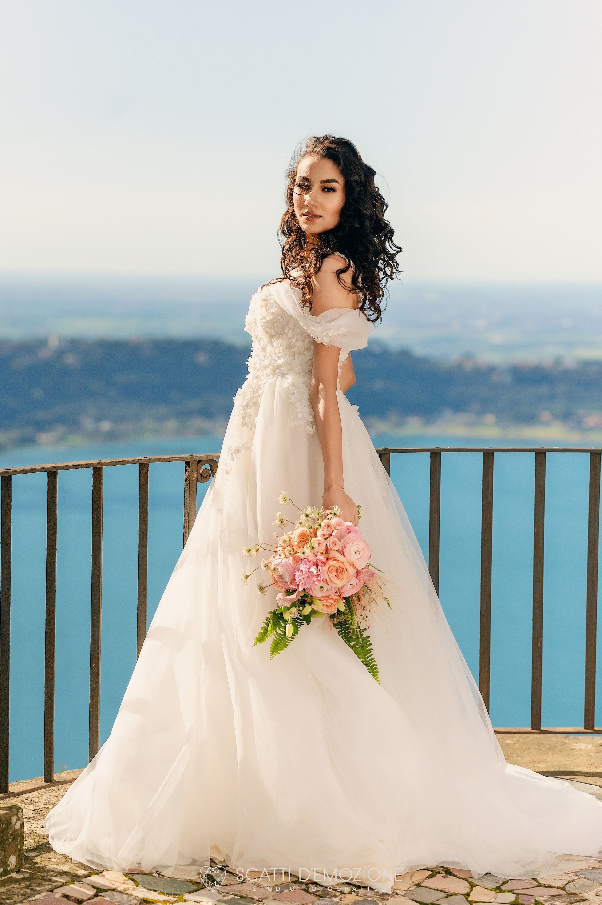 ritratto sposa sotto il sole con vestito bianco e bouquet davanti al lago di Castel Gandolfo
