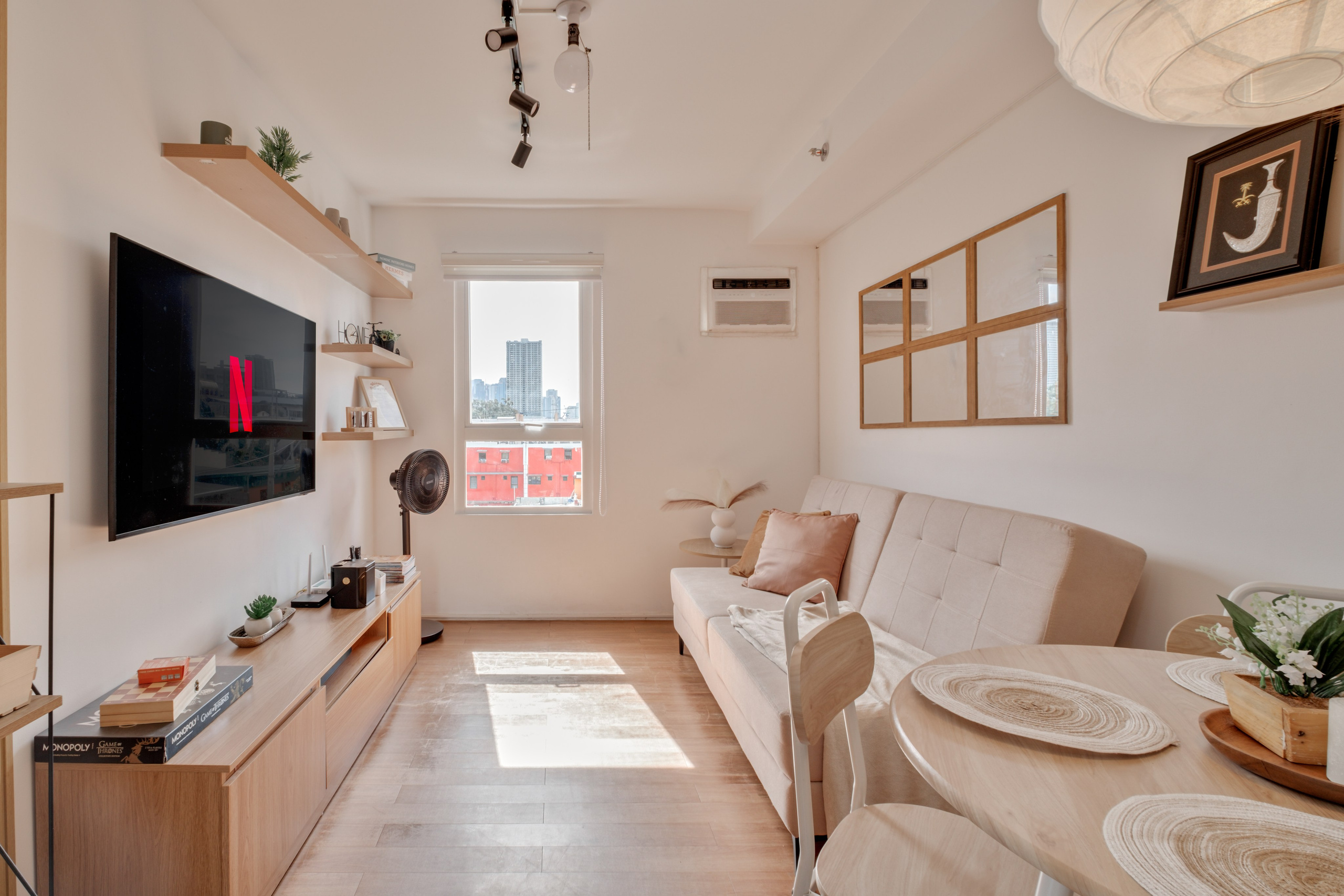 Professional interior photograph of a modern condo featuring a minimalist living room, dining area, warm wood finishes, and soft natural lighting.