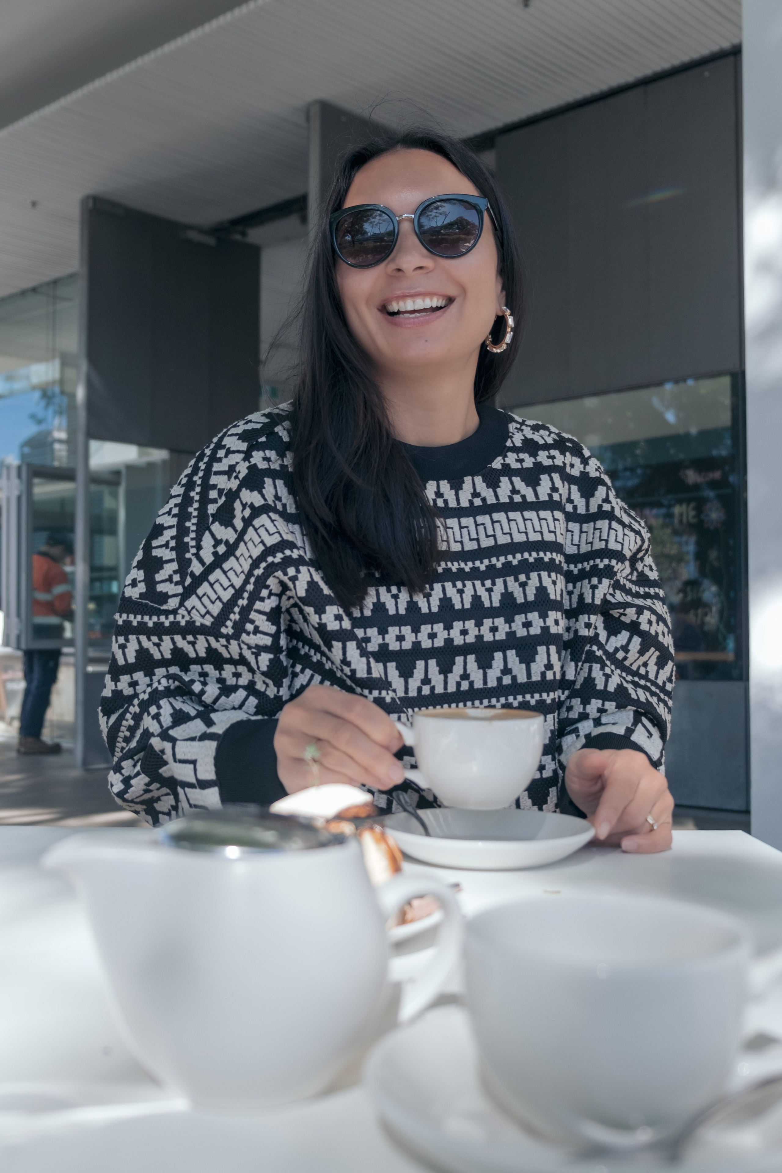 Woman enjoying coffee at a cozy cafe, lifestyle portrait photographer.
