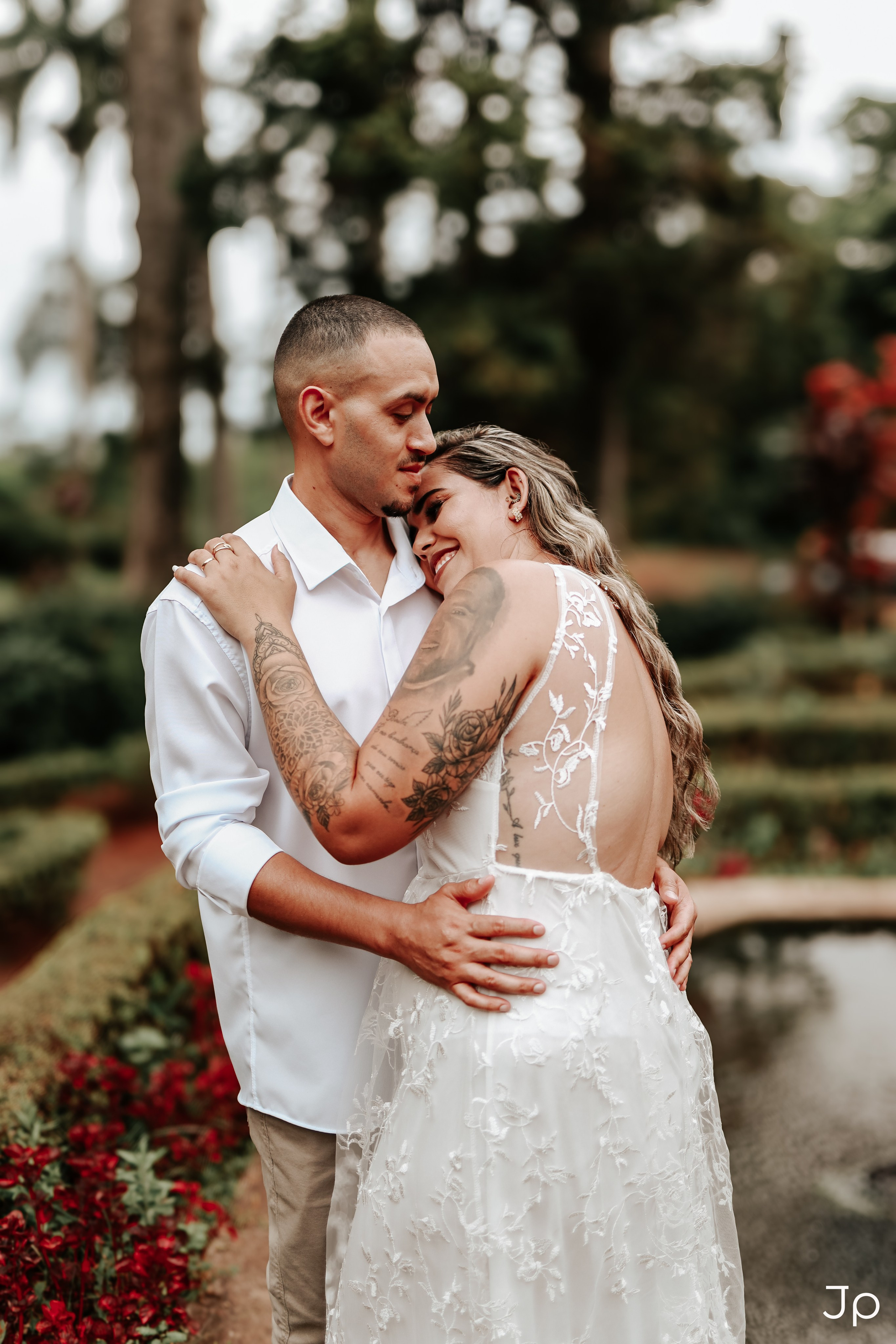 Fotógrafo em Pederneiras registra beijo apaixonado em meio ao jardim florido durante ensaio de casal.