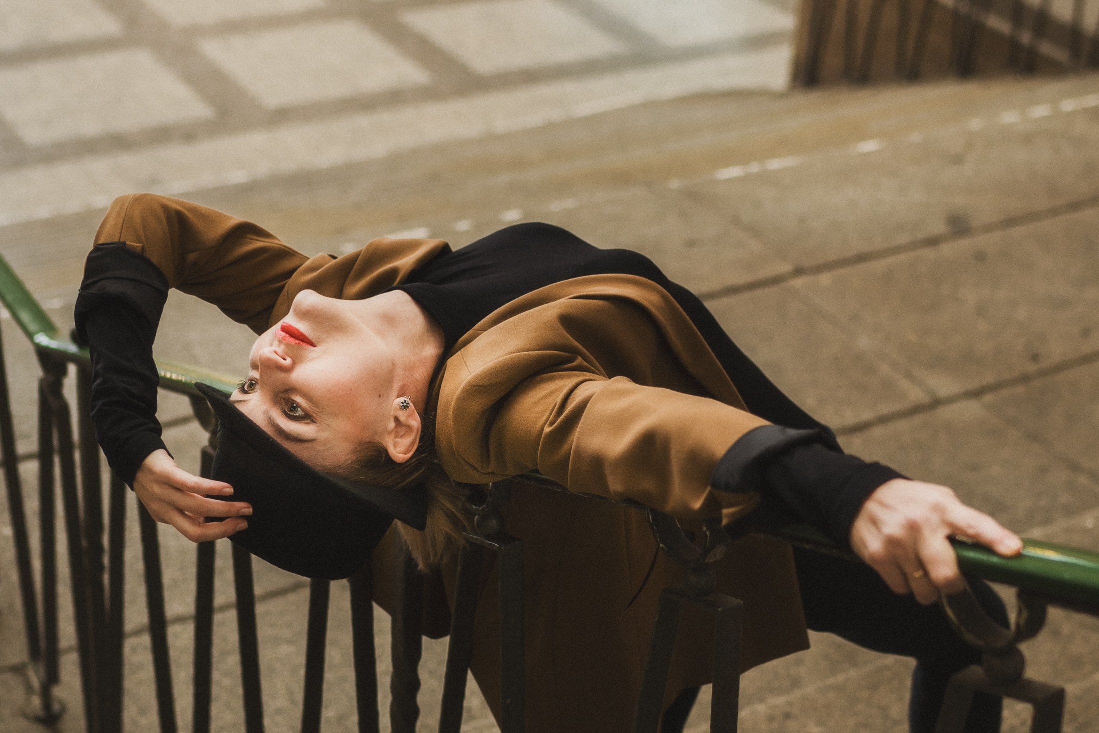 Dynamische Pose auf der Treppe, Frau im braunen Mantel mit Hut