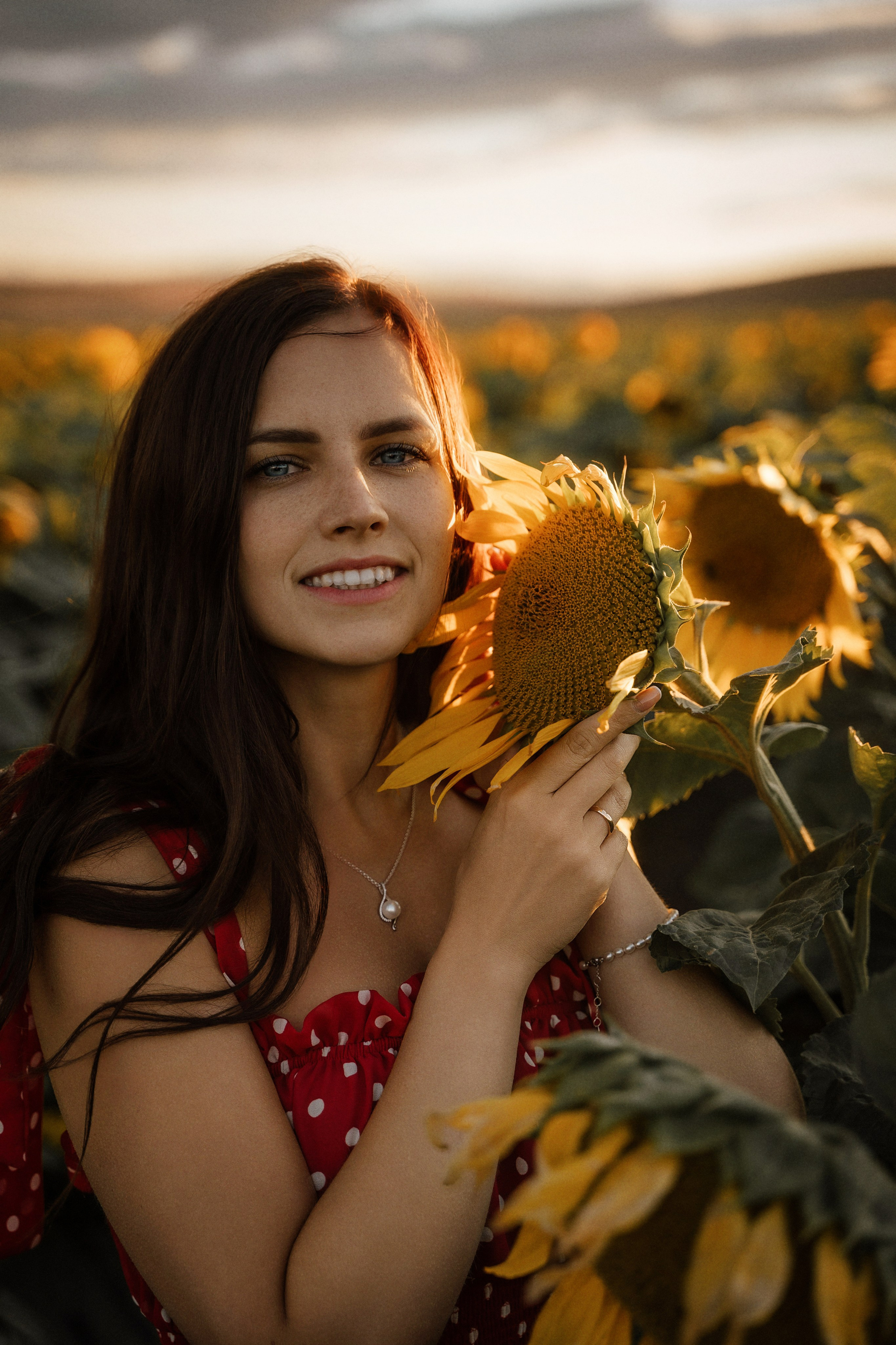 Elegant portrait of a young woman posing in sunflower field at sunset, Marbella