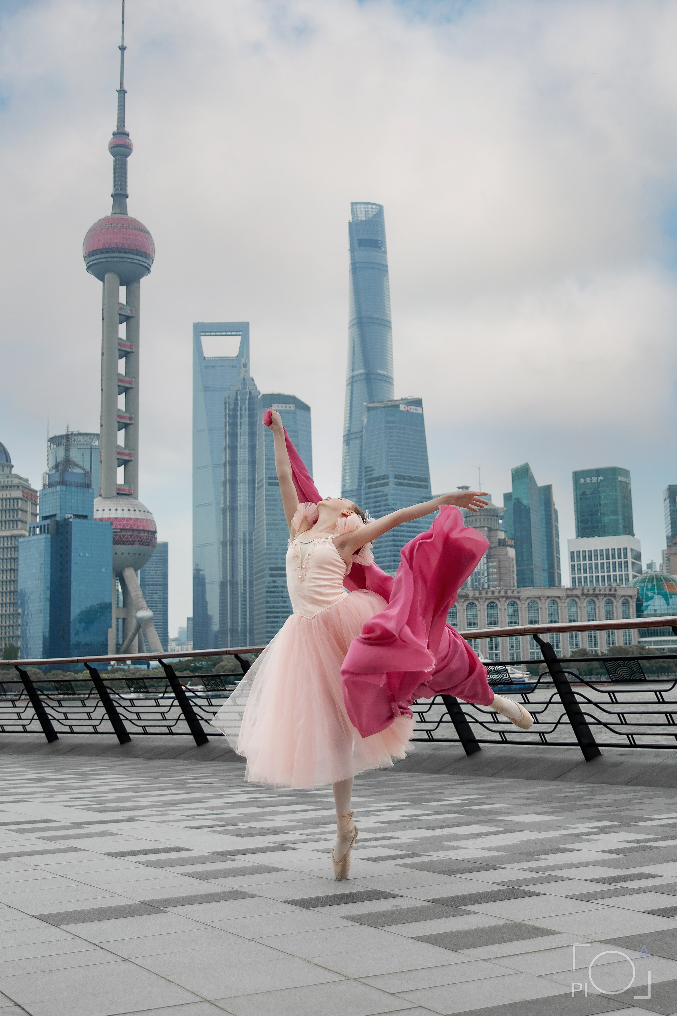 Фотосессия в Шанхае для девочки 11 лет. Маленькая балерина в розовом платье с пышной длинной пачкой и малиновой развивающейся тканью, танцует на набережной в Шанхае с видом на Lujiazui