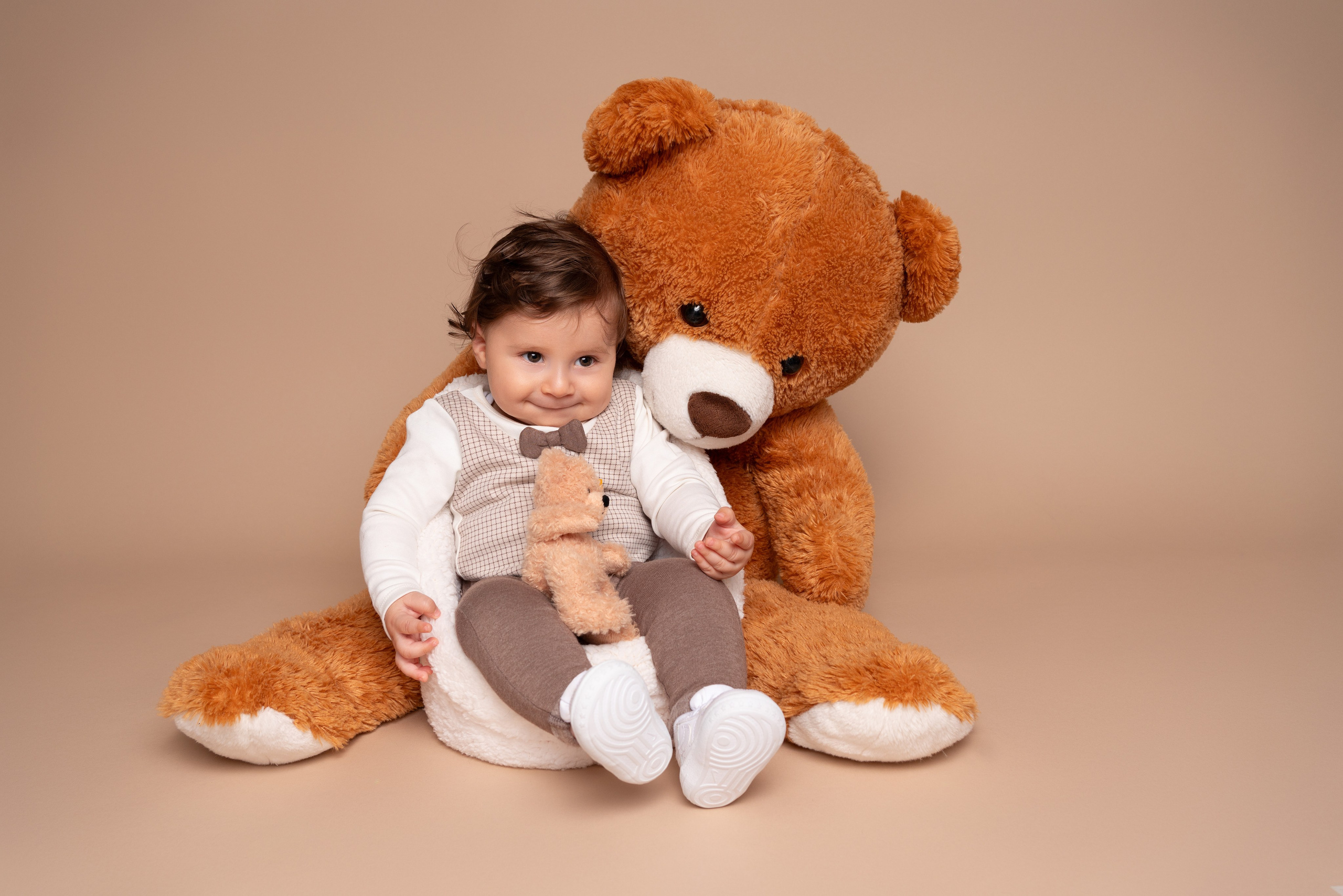 Studiofoto eines fünf Monate alten Jungen in den Armen eines großen Teddybären