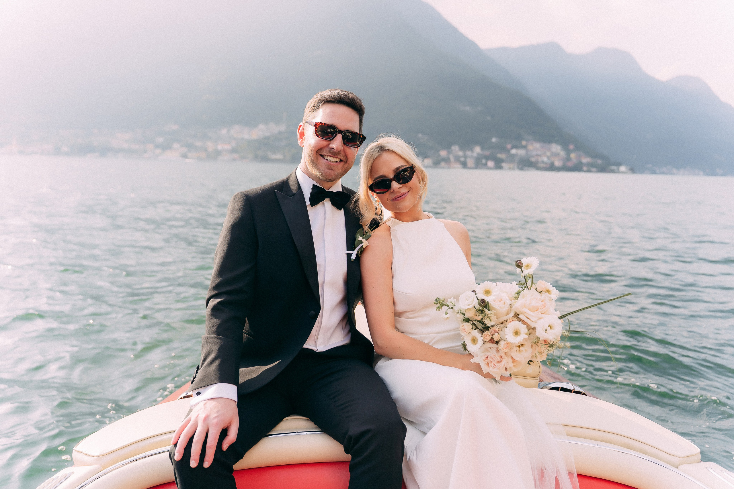 Bride and groom sitting together on the boat at Villa Lario, Lake Como, Italy