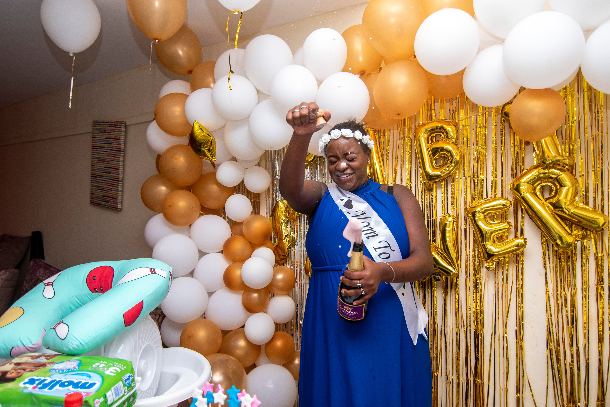 A mom-to-be pops champagne at her babyshower event in Nairobi
