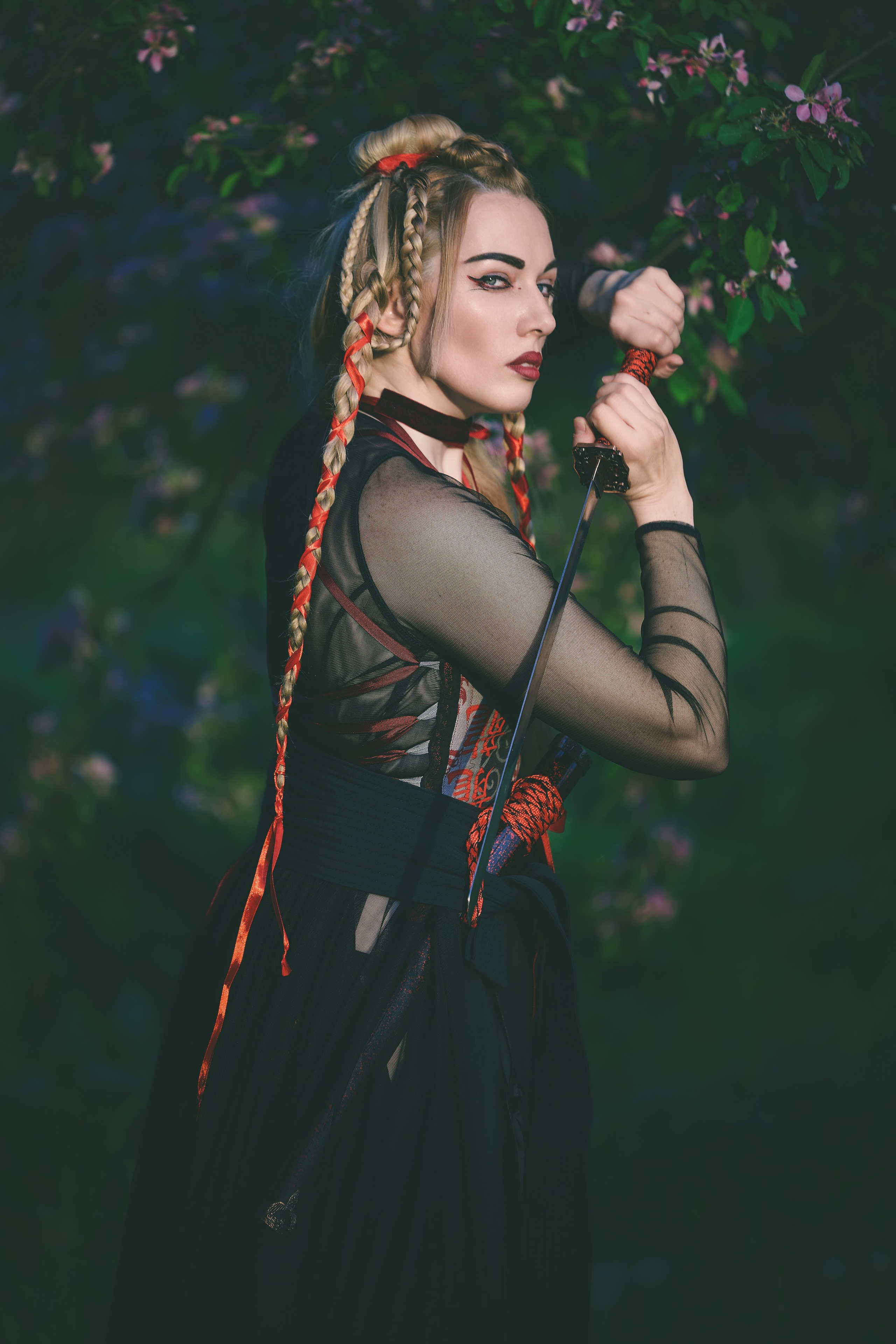 Уличная фотосесия красивая девушка с мечем катана в цветах яблони сакуры