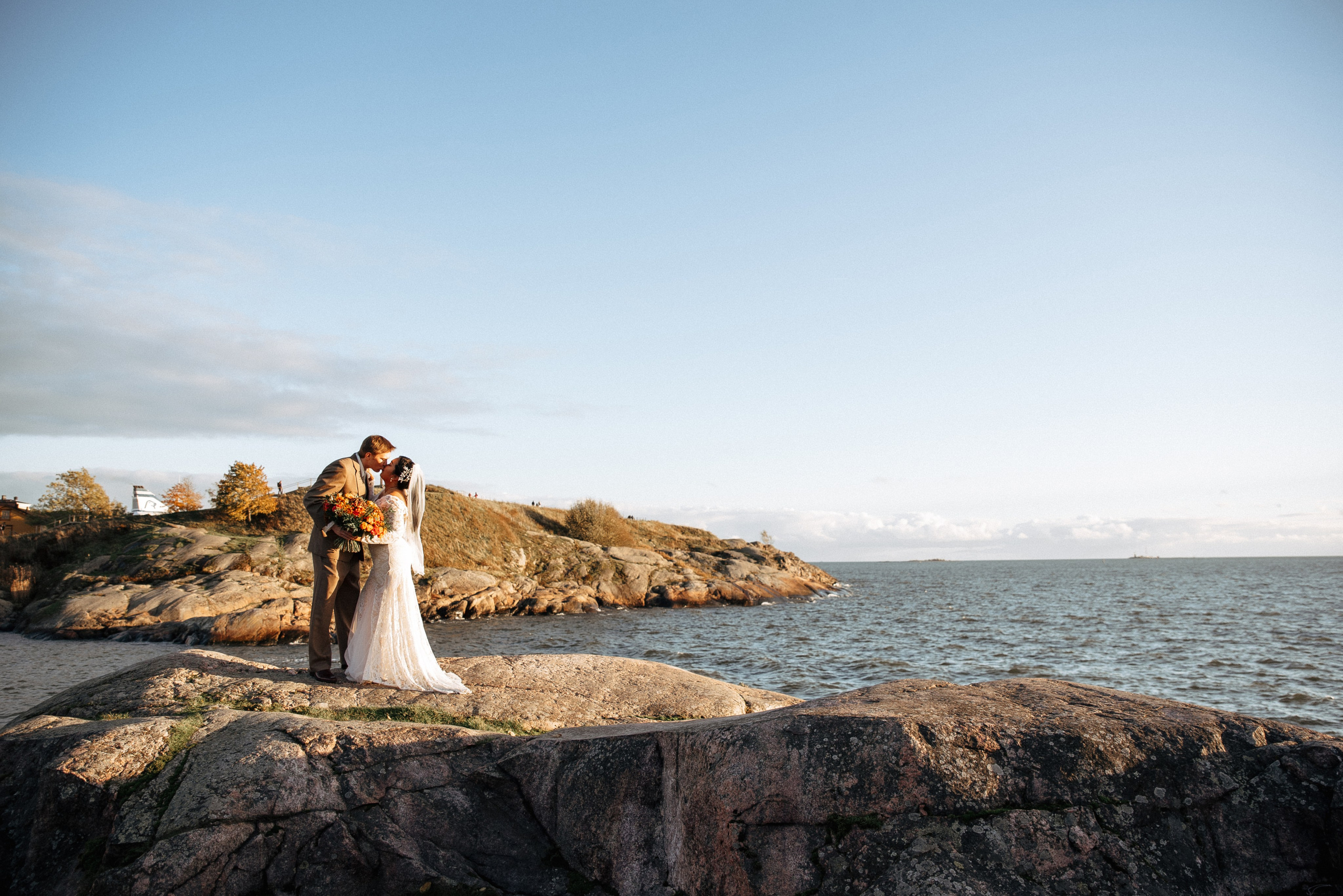 Красивая свадебная пара позирует на живописной локации в Финляндии.