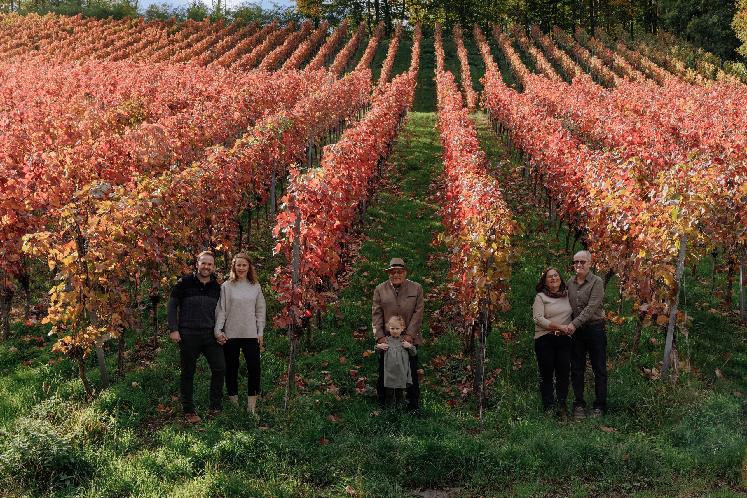 Familien-Fotoshooting mehrerer Generationen im herbstlichen Weinberg.