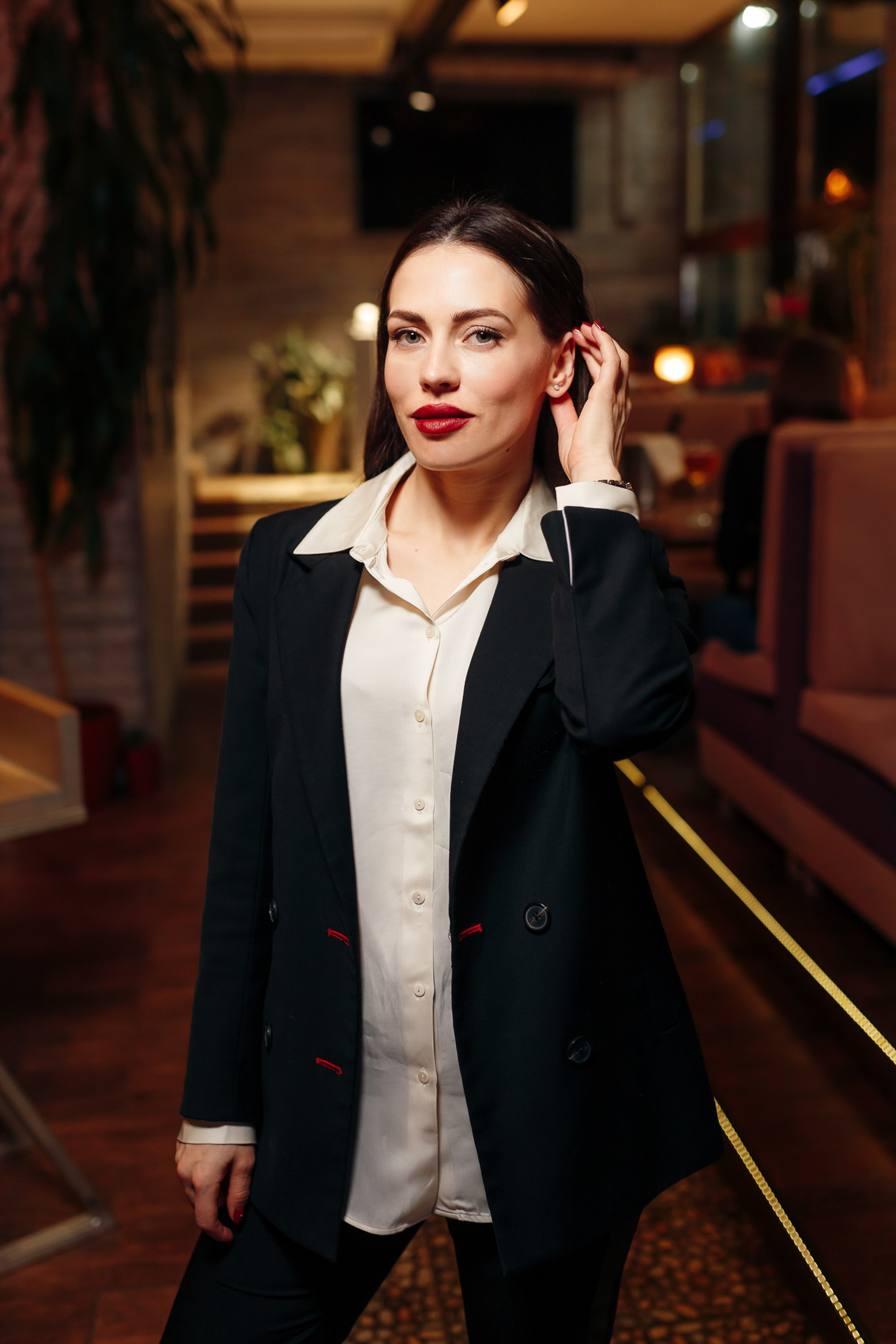 Young man in black coat standing in a bar