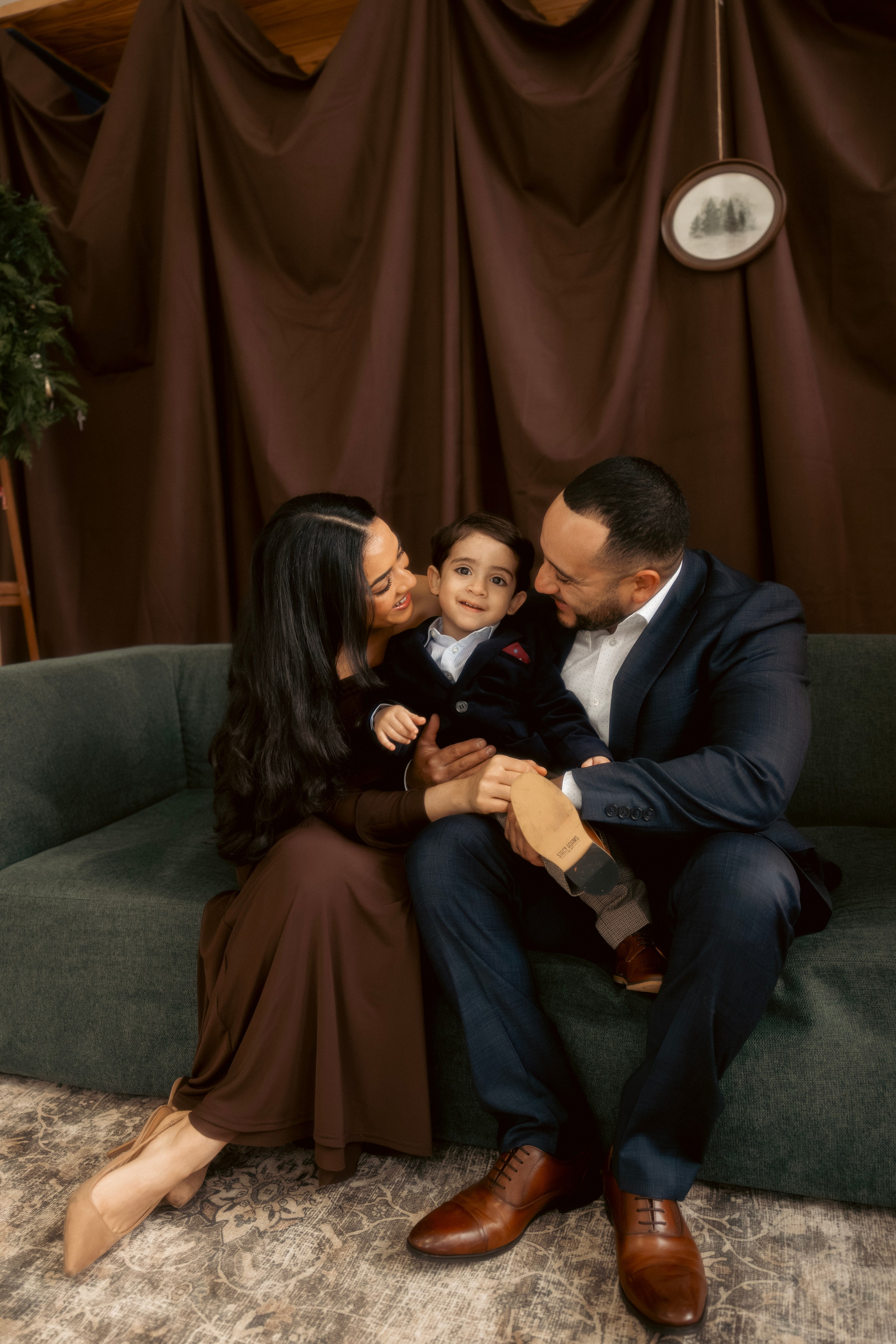 Little boy sitting beside Christmas tree in cozy Chicago studio