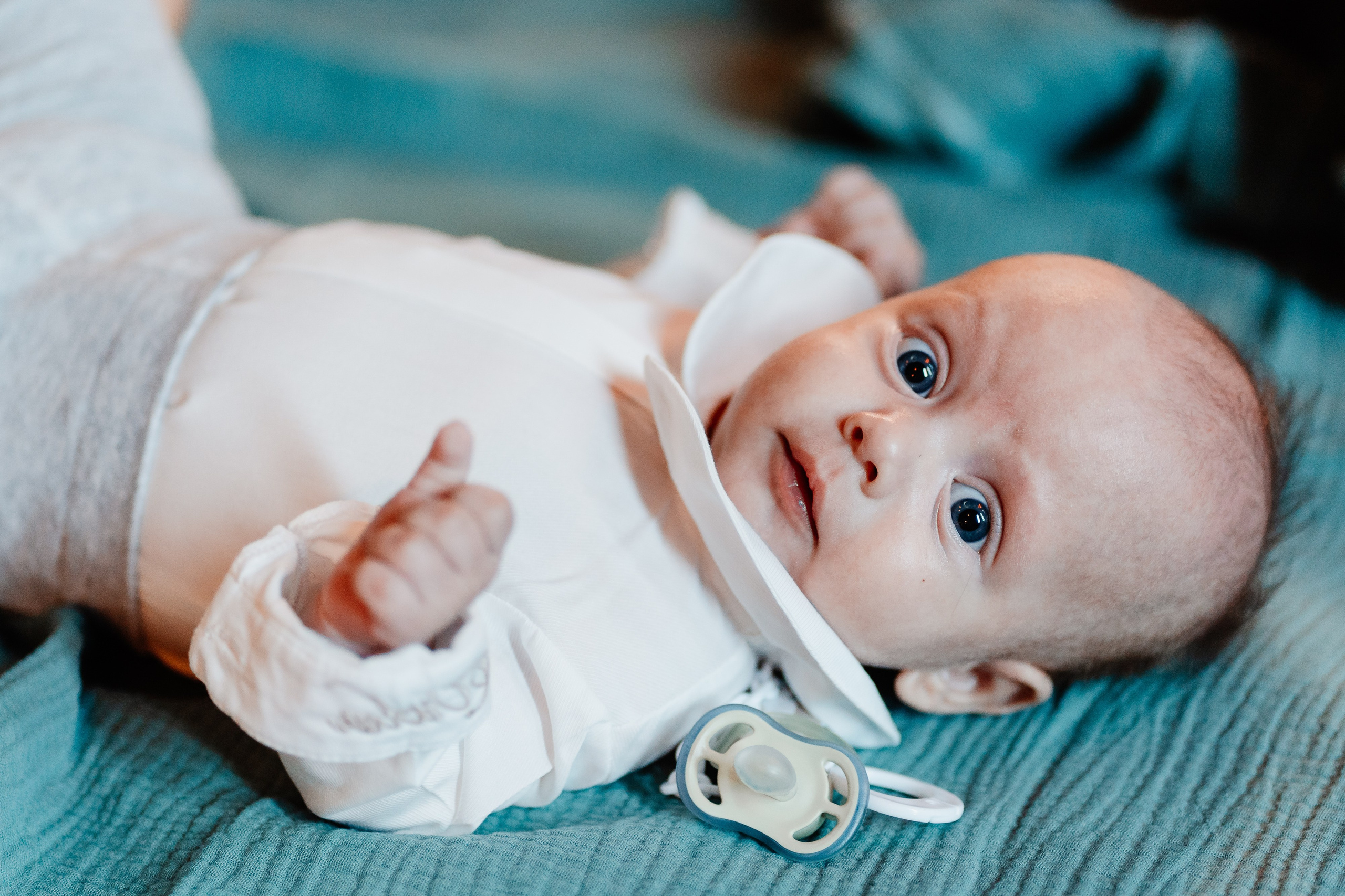 Instantaneu plin de tandrețe dintre părinți și bebeluș în ziua botezului, realizat în Craiova. Fotografie profesională de botez, capturând emoțiile autentice ale familiei într-un decor luminos și cald