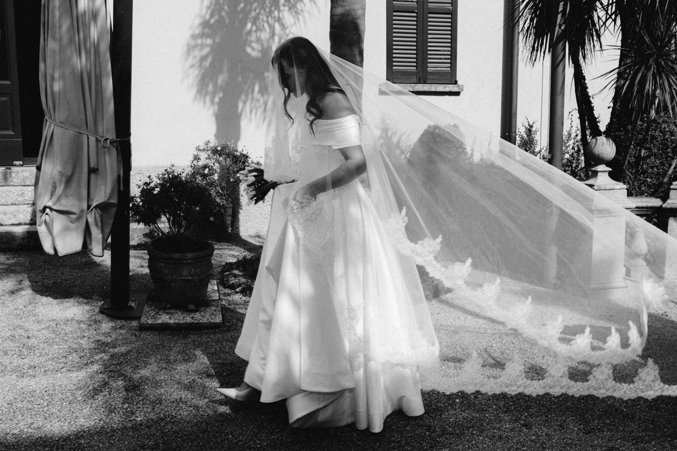 Bride walking with a long lace veil during a Bellagio elopement on Lake Como