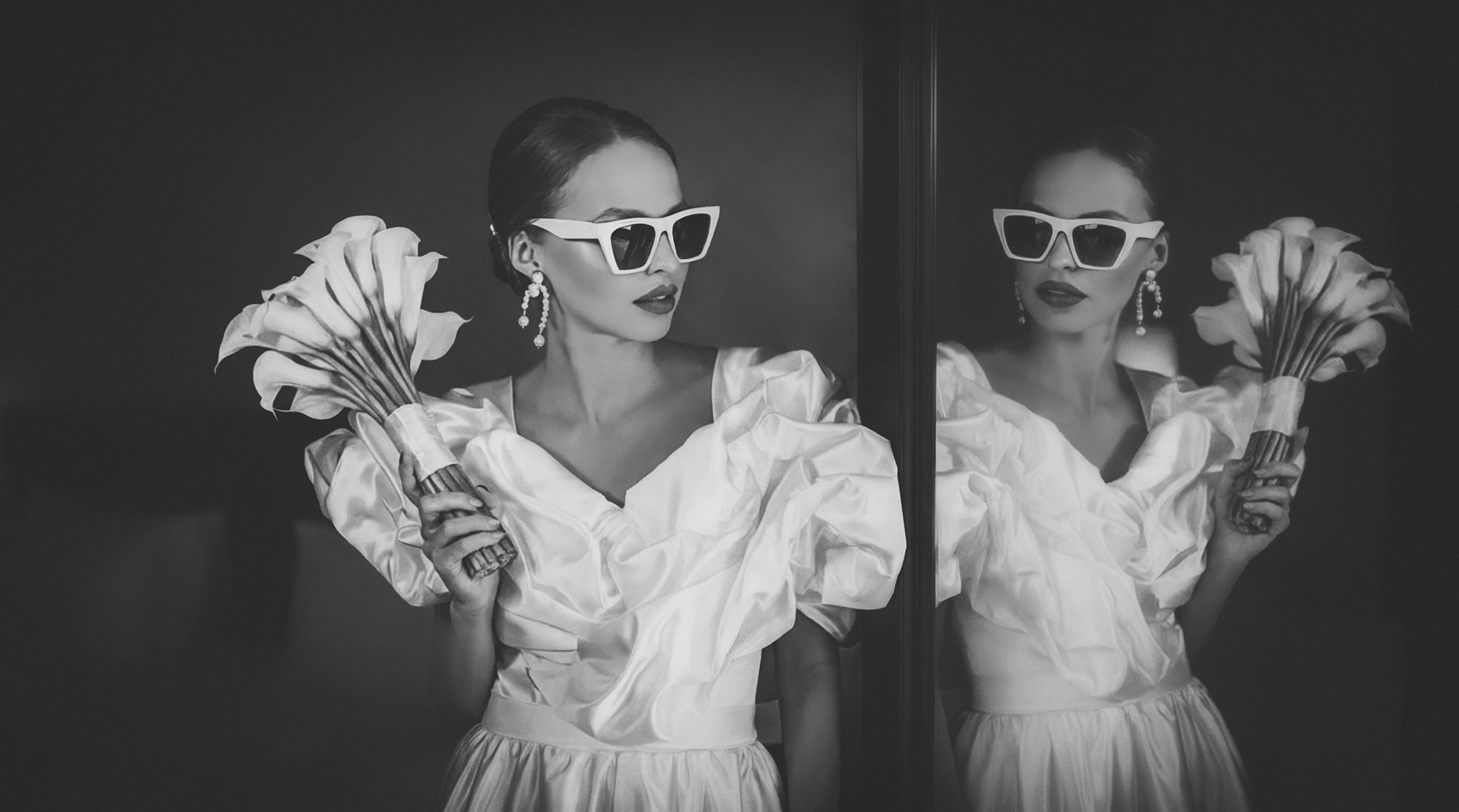 Editorial black and white portrait of a bride wearing sunglasses captured in a mirror reflection. Destination wedding photographer for international clients
