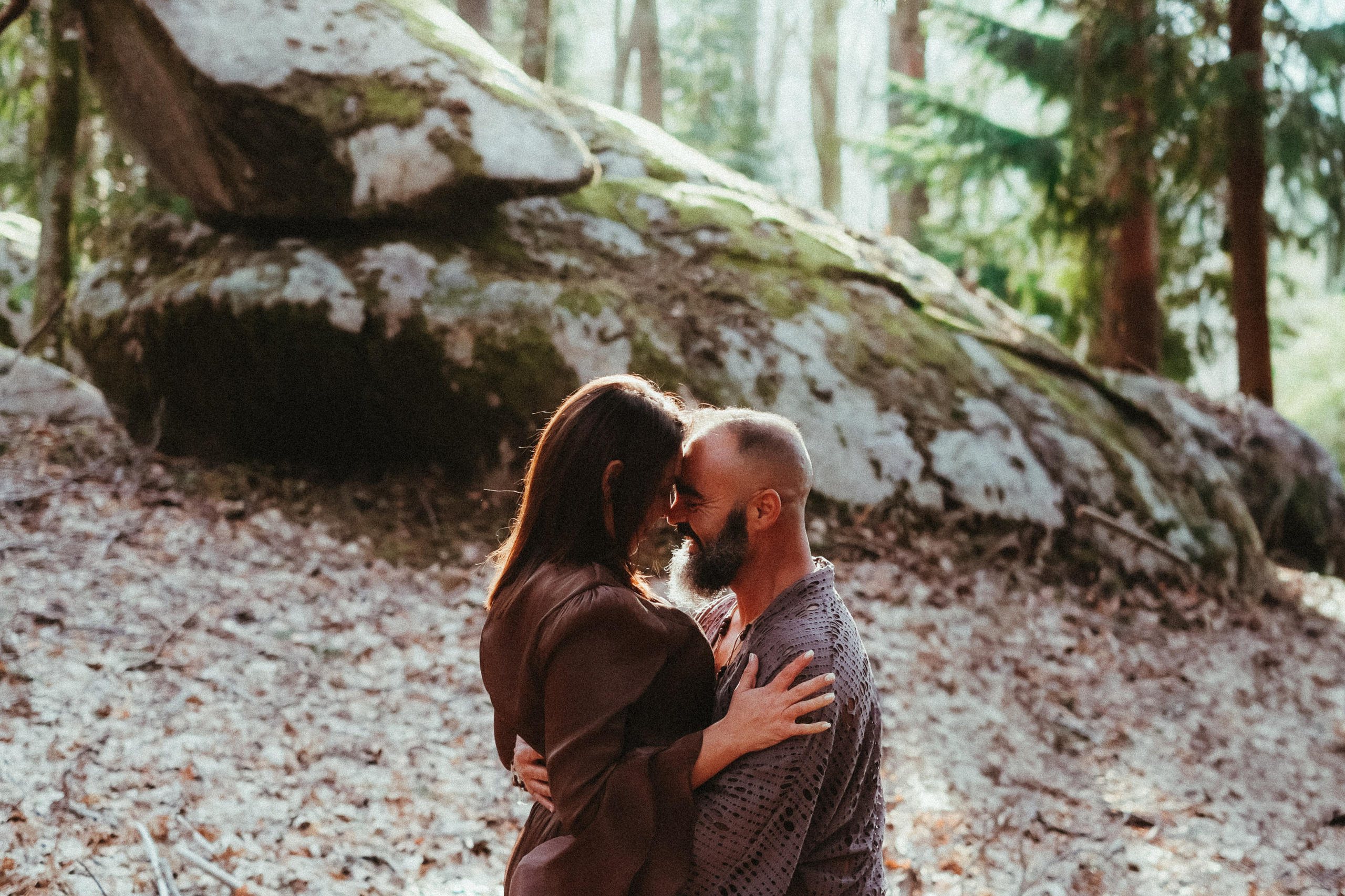 Couple on mossy rock during forest engagement session in Portugal