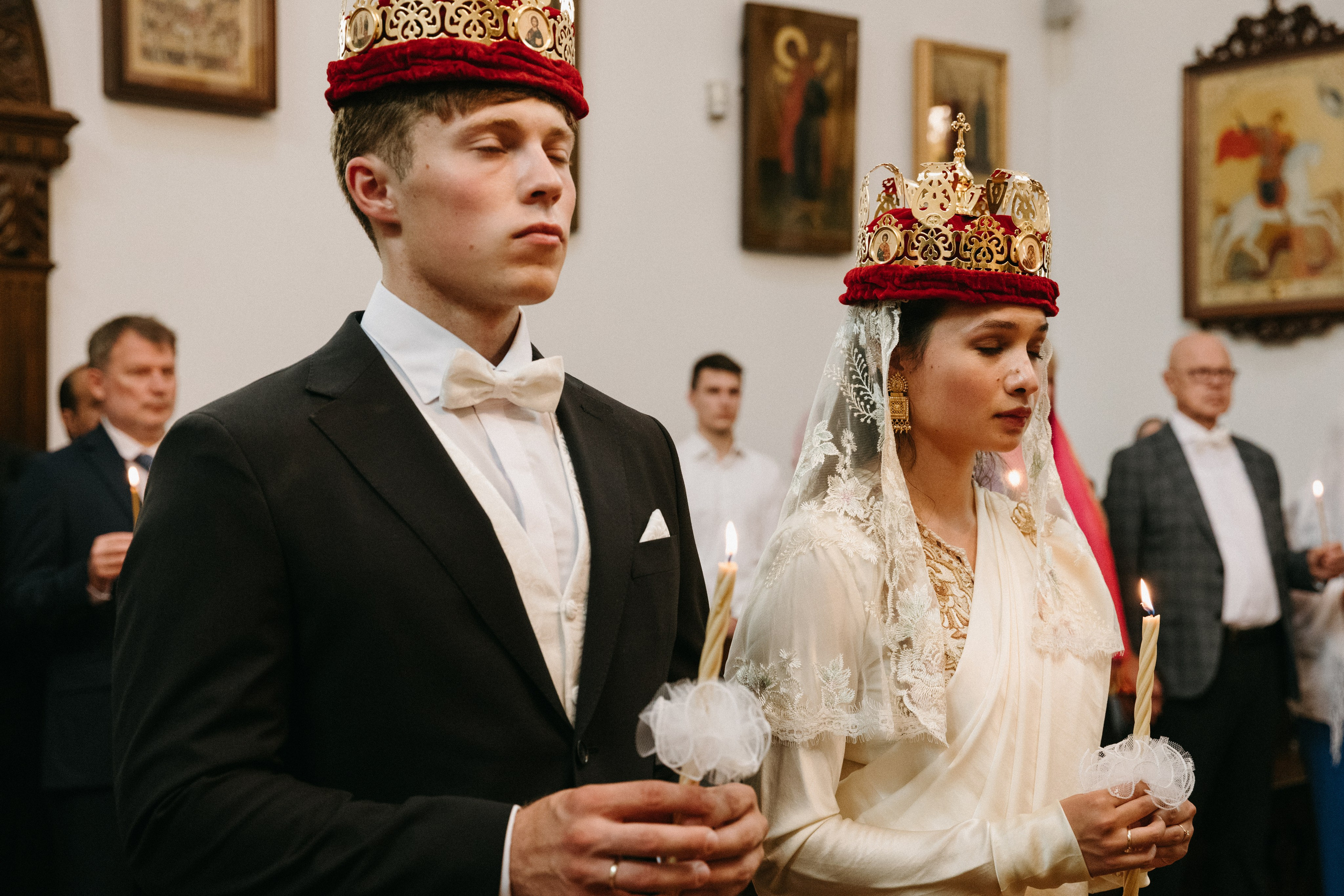 Braut und Bräutigam mit prunkvollen Kronen und Kerzen bei der orthodoxen Trauungszeremonie