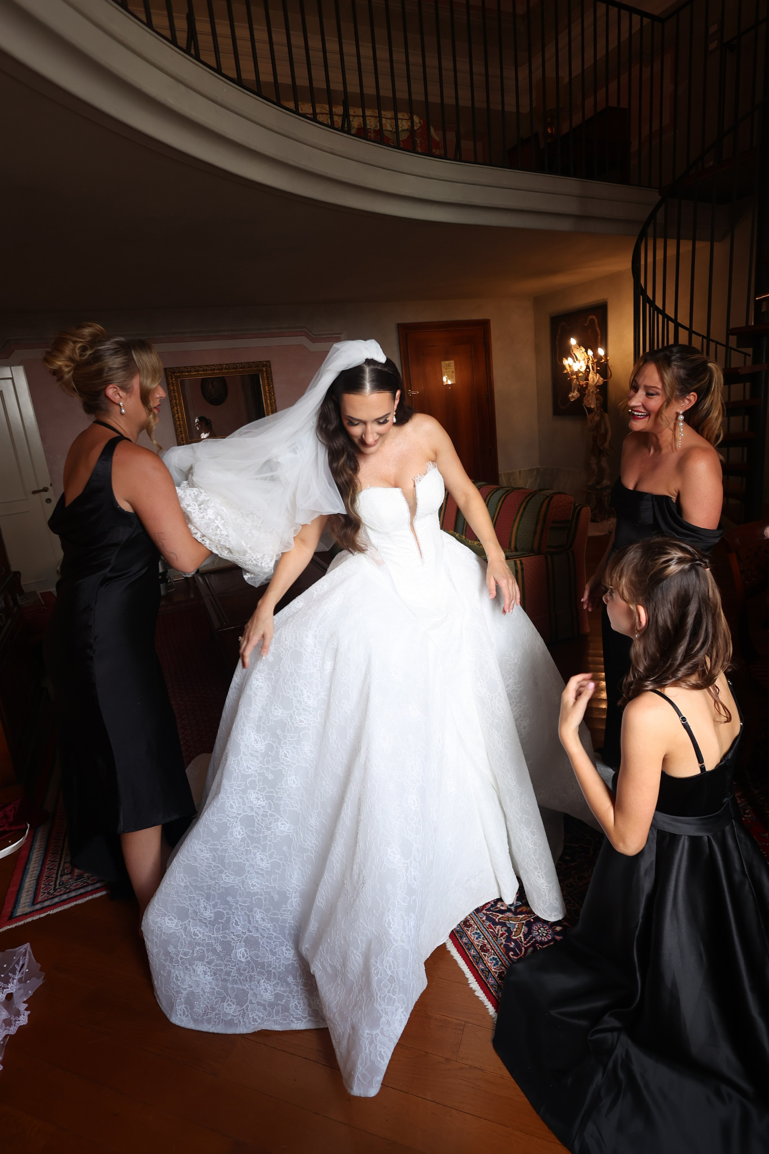 Candid moment of the bride surrounded by bridesmaids during preparations.