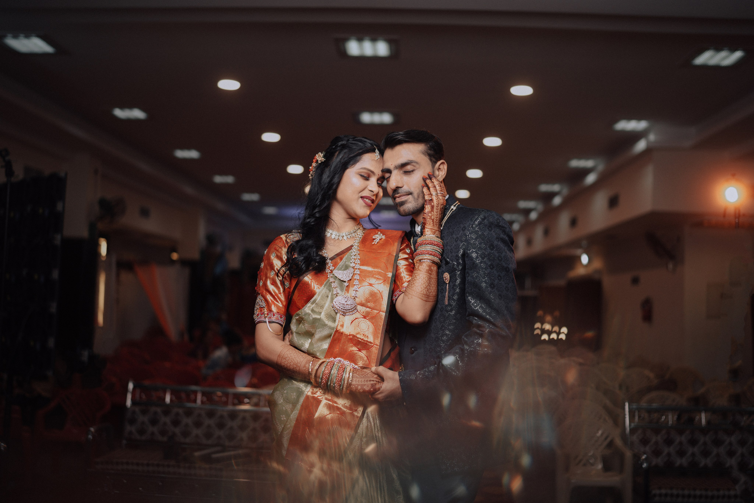 professional indoor photograph of a newly married South Indian couple in traditional attire posing during their wedding reception in Malleshwaram, Bengaluru