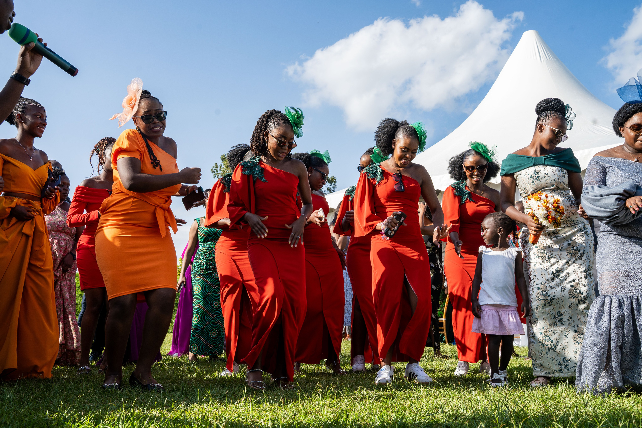 A low-angle full portrait of bridesmaids dancing at an outdoor wedding reception