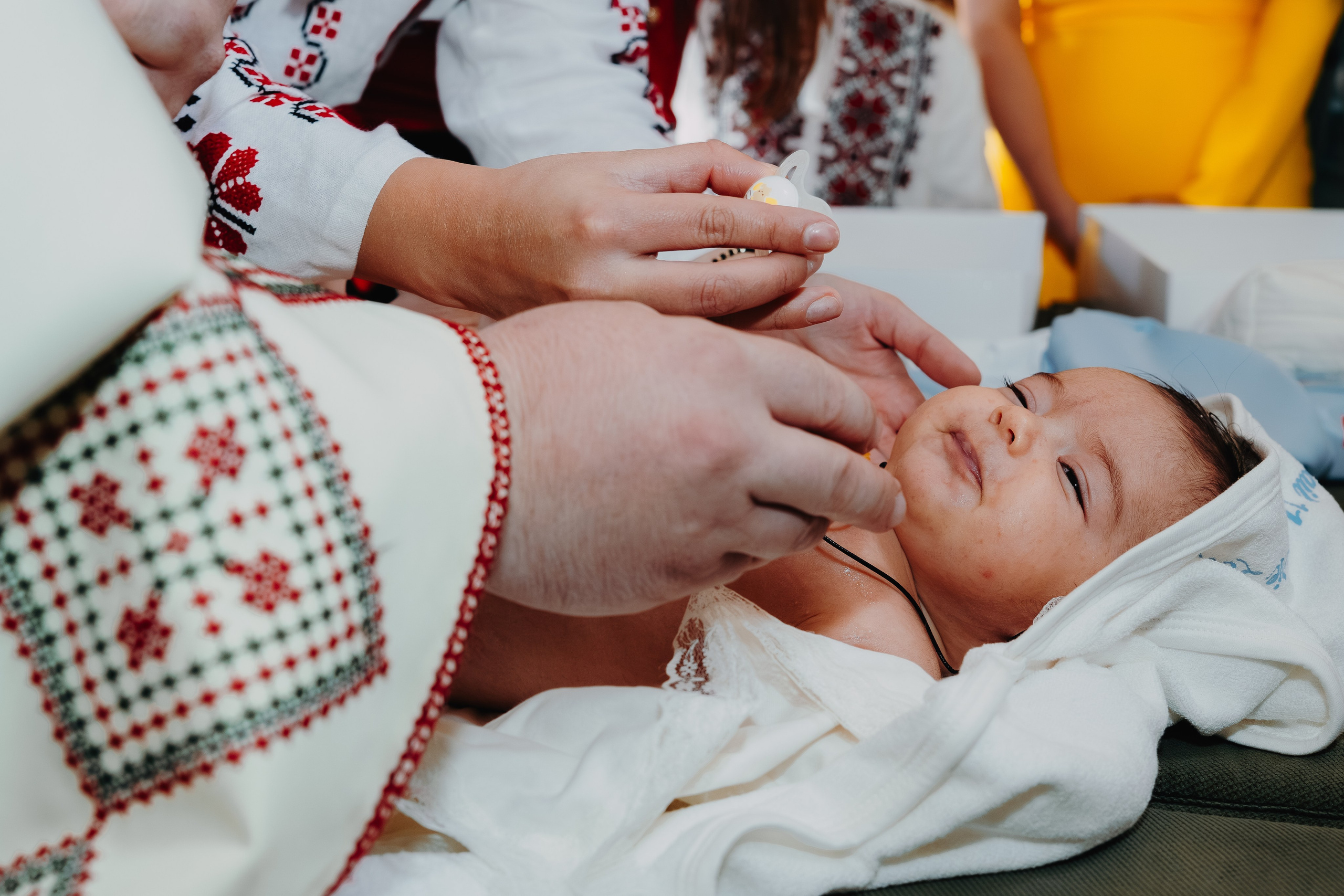 Ritualul ungerei cu mir sfânt a pruncului Arthur Mihail, la botez în Catedrala Bârlad. Preotul aplică mirul cu grijă pe frunte, în timp ce nașii și familia asistă. Un moment solemn și profund simbolic al tainei botezului.