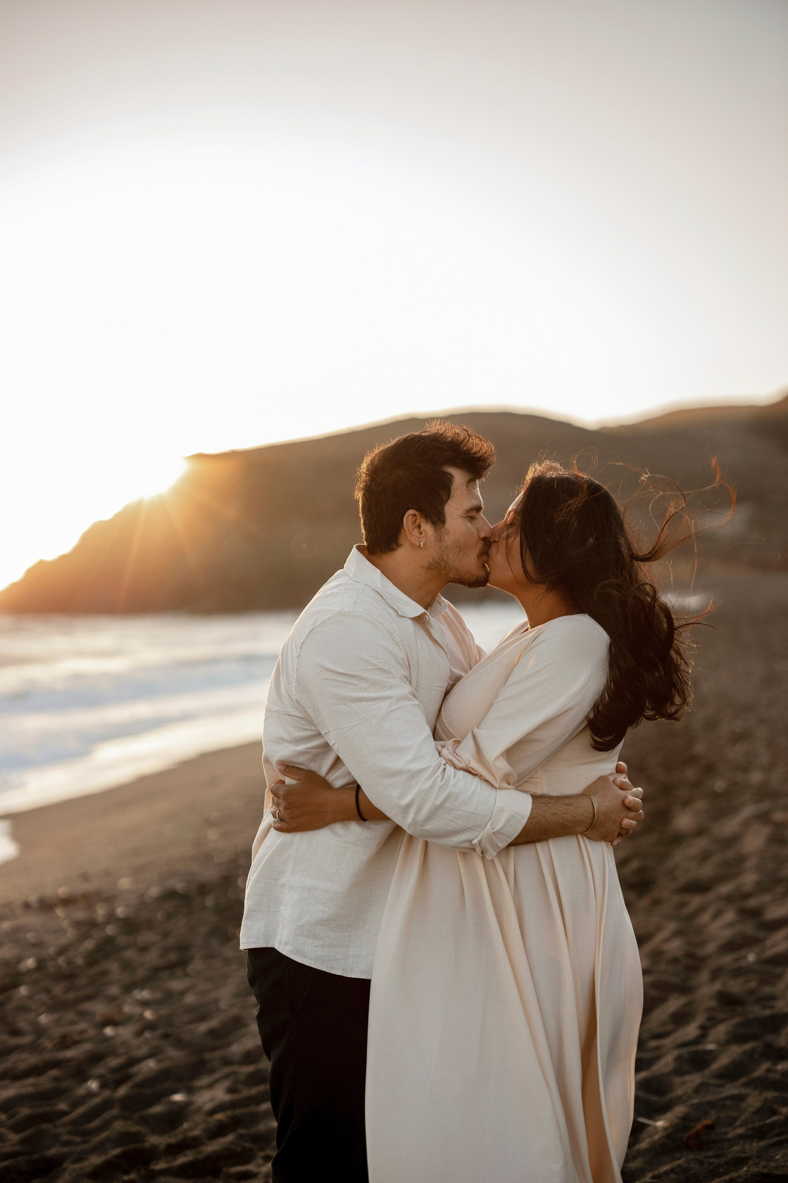 Couple maternity portraits by the ocean during golden hour