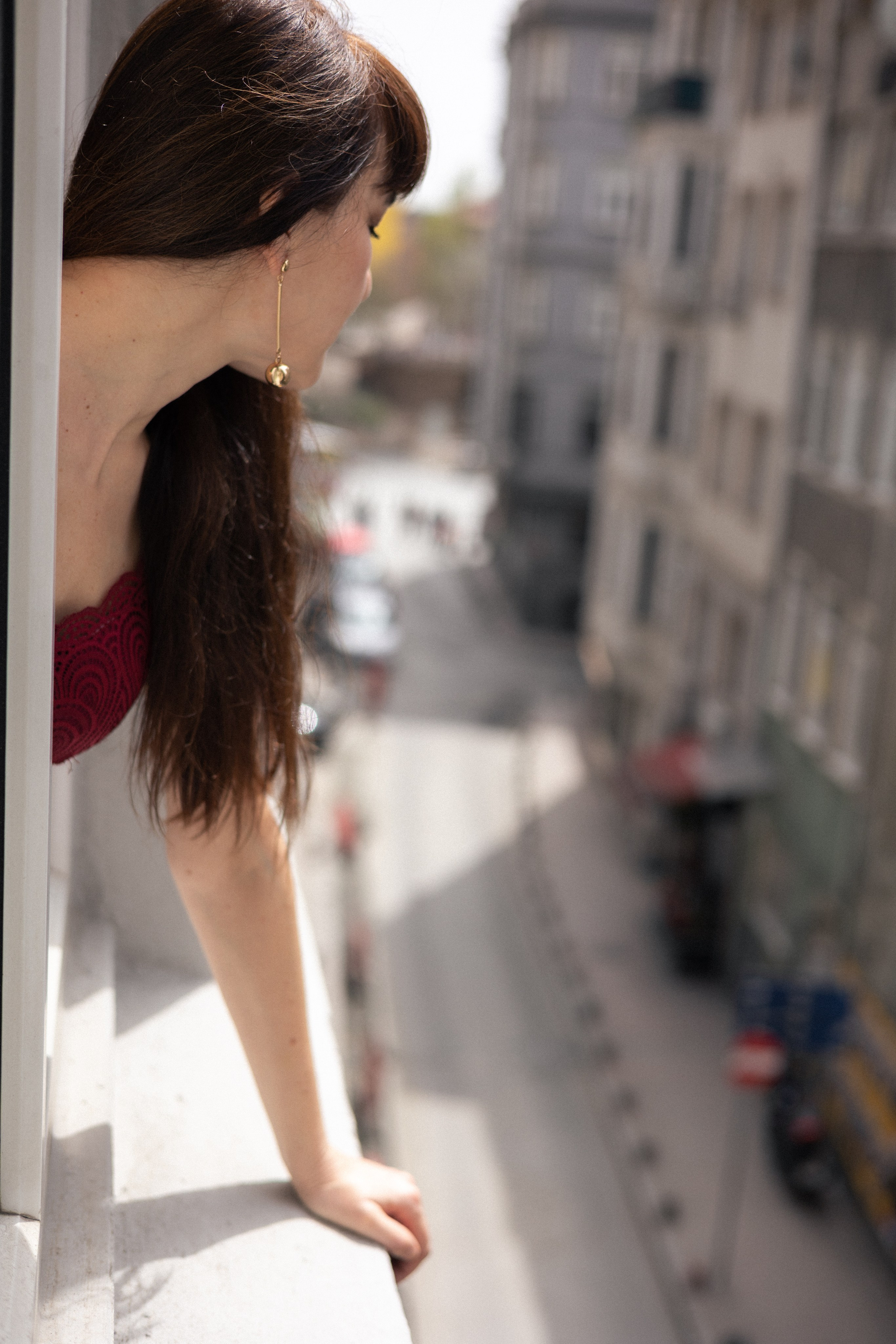 Женщина выглядывает из окна и смотрит вниз на улицу Стамбула, городской пейзаж с мягким дневным светом