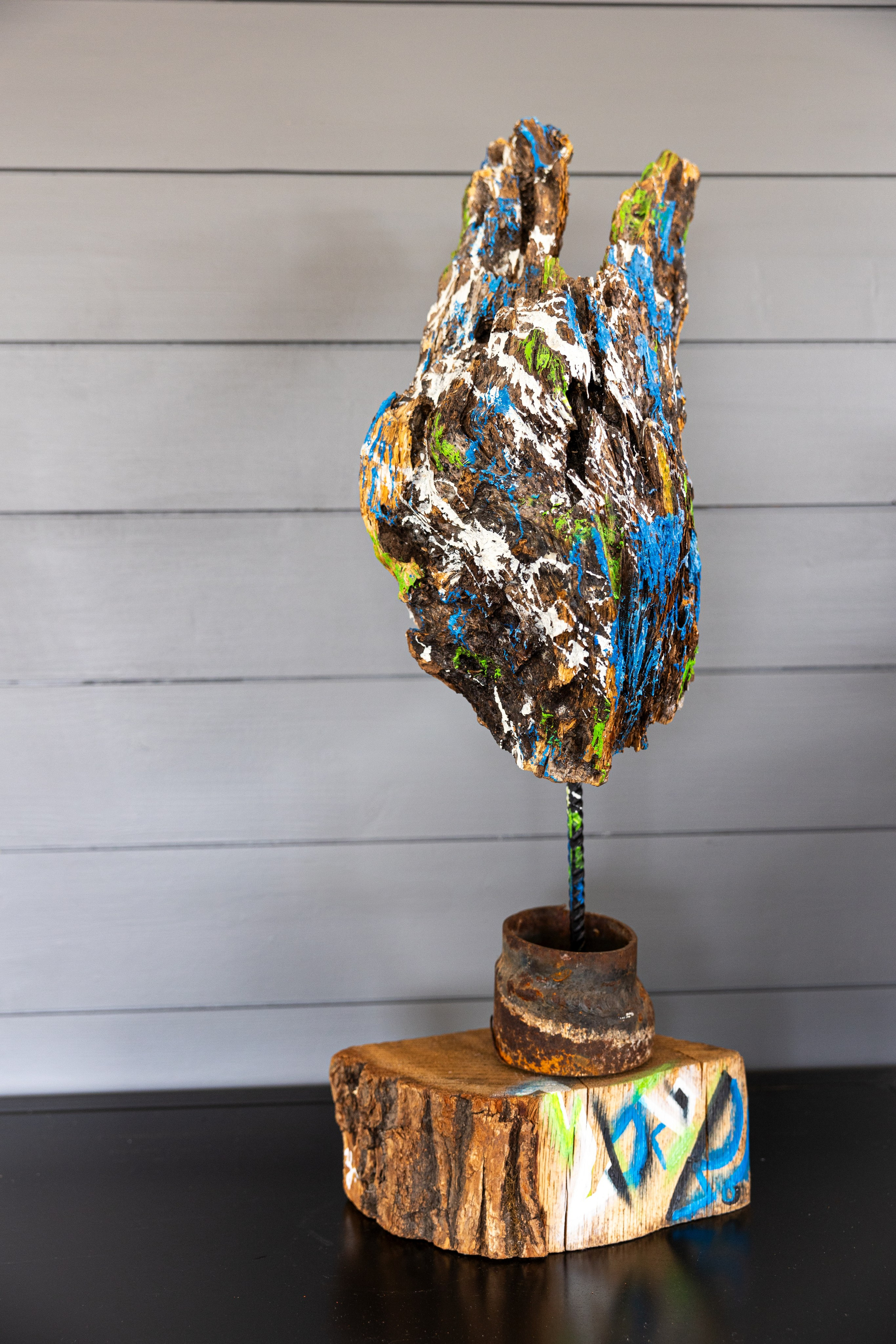 Wood head on a metal stick splashed with acrylic 