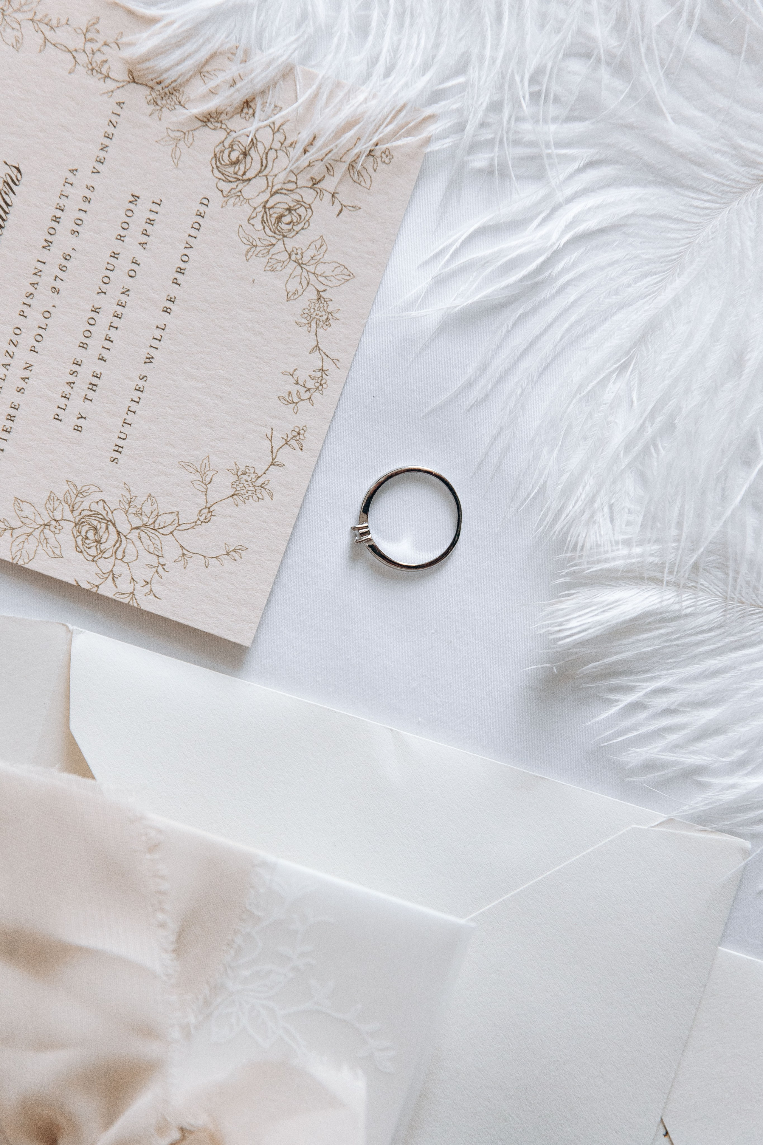 Close-up of elegant wedding rings and stationery with intricate designs, captured during a French wedding