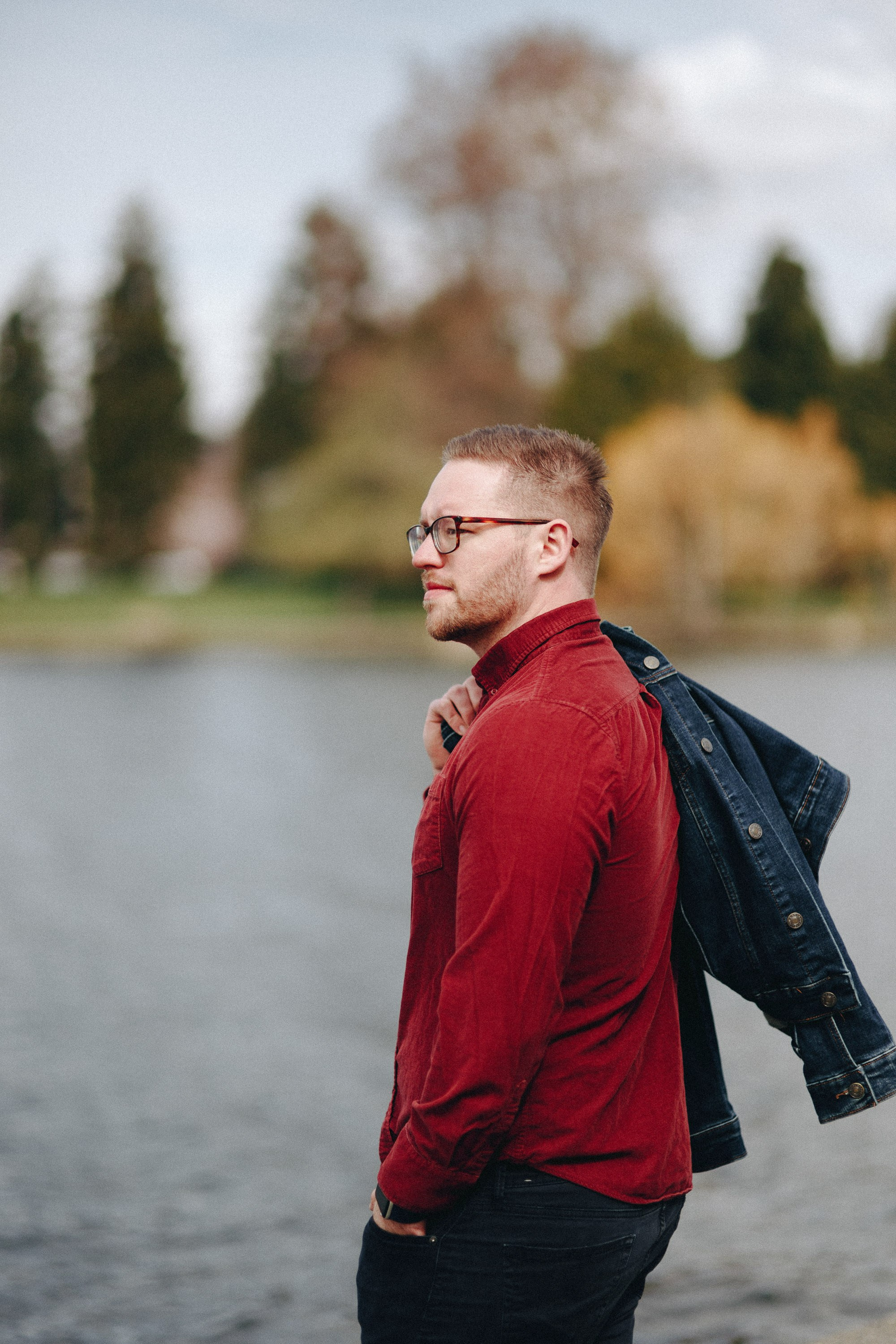Man in red sweater outdoors looking back