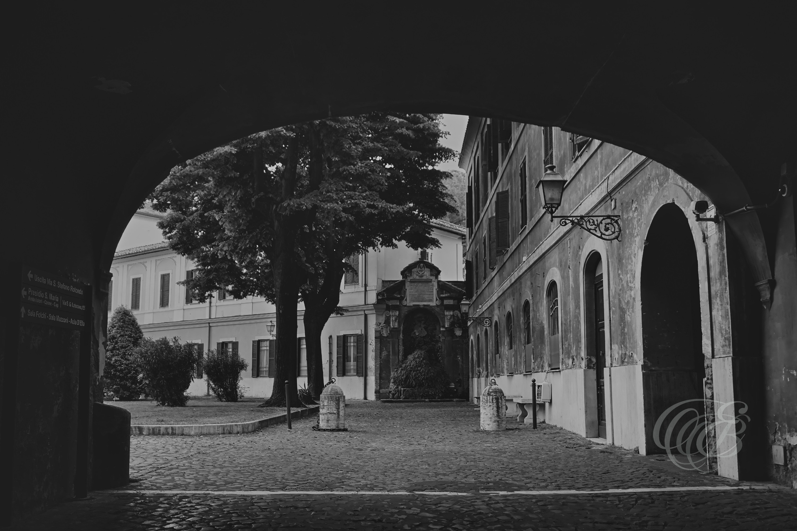 Street Photography — Rome, Italy — San Giovanni Hospital Archway — B&W Matte — Matte black and white interpretation of a historic archway within Rome’s San Giovanni hospital complex, emphasizing architectural form, tonal depth, and the enduring character of the Lateran area — Eduardo Bartoli Photography.