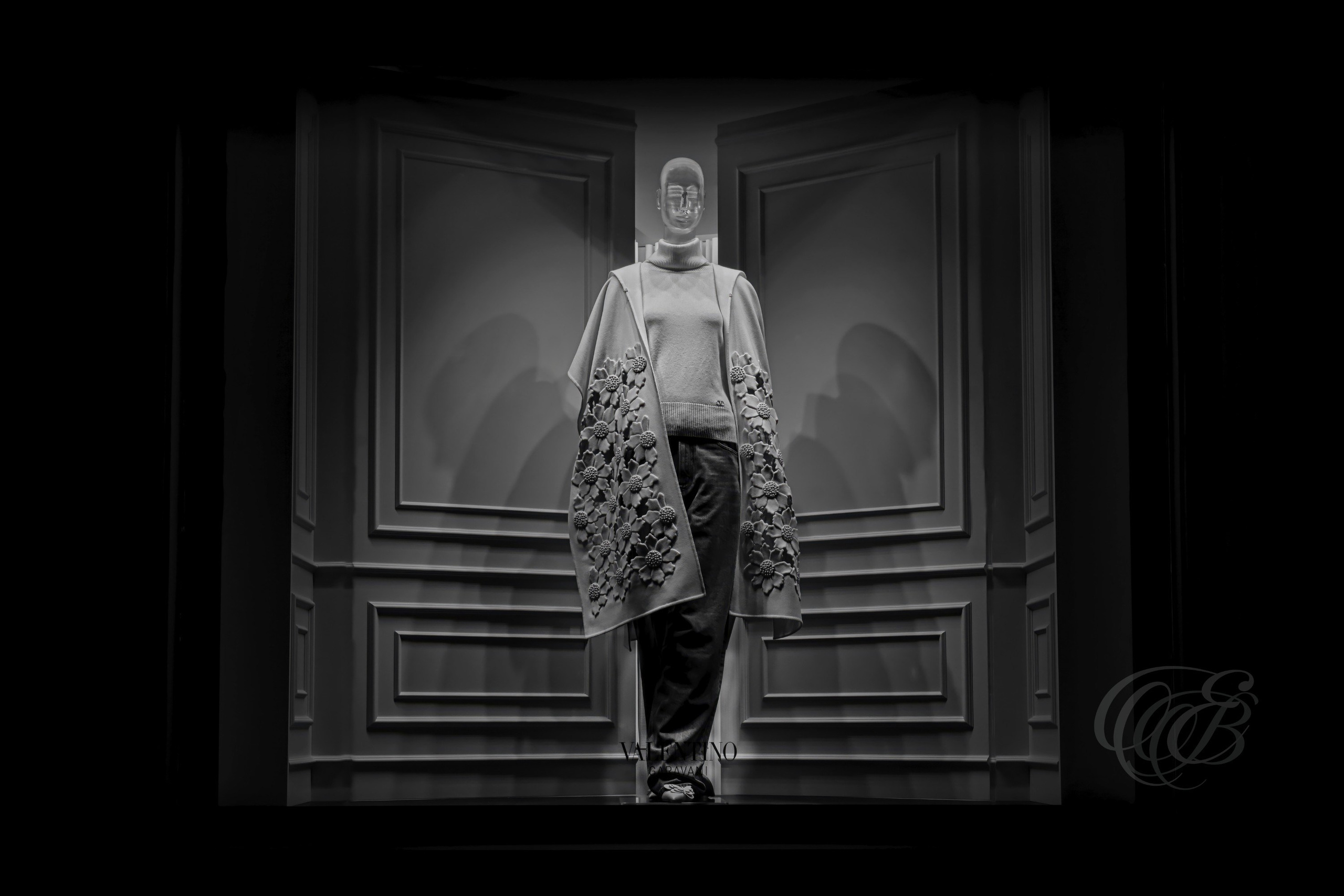 Street Photography — Rome, Italy — Valentino Boutique Window Display — B&W — Black and white study of a Valentino boutique window in Rome, emphasizing a softly illuminated mannequin, Italian fashion design, tonal contrast, and the refined atmosphere of the nighttime display — Eduardo Bartoli Photography.