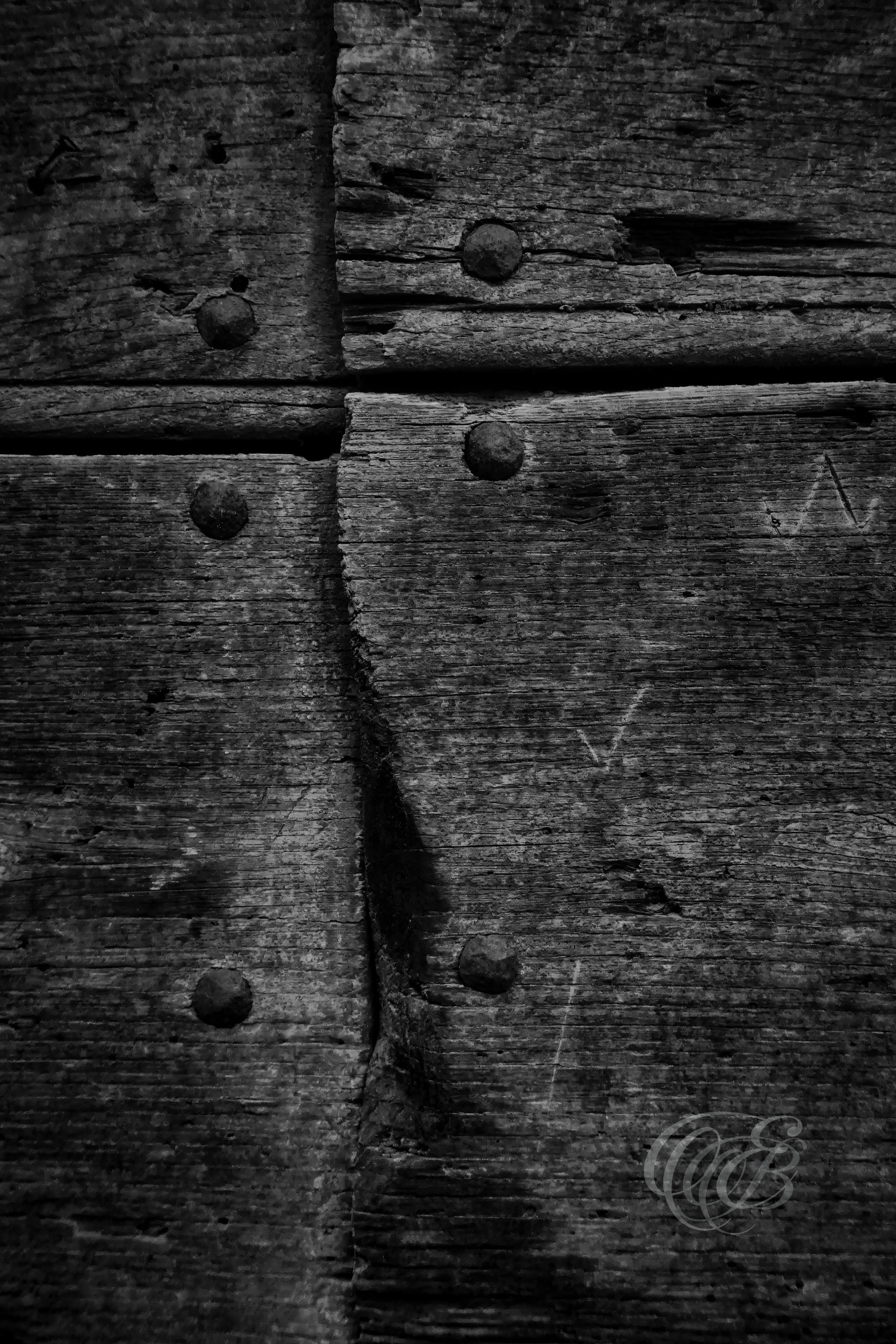 Street Photography — Rome, Italy — Old Door Close-Up — B&W — Black and white close-up of an old wooden door in Rome, emphasizing natural grain, weathered surfaces, aged details, and traditional materials shaped by time — Eduardo Bartoli Photography.