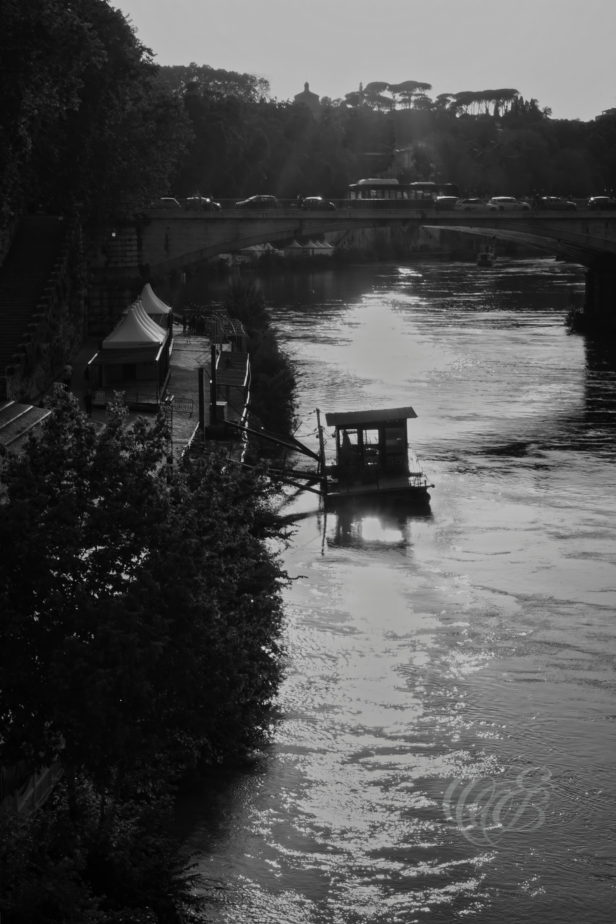 Street Photography — Rome, Italy — The Tiber at Sunset — B&W — Black and white view of the Tiber at sunset, emphasizing reflections, evening light, riverbank textures, and the atmosphere of Rome’s historic waterway — Eduardo Bartoli Photography.
