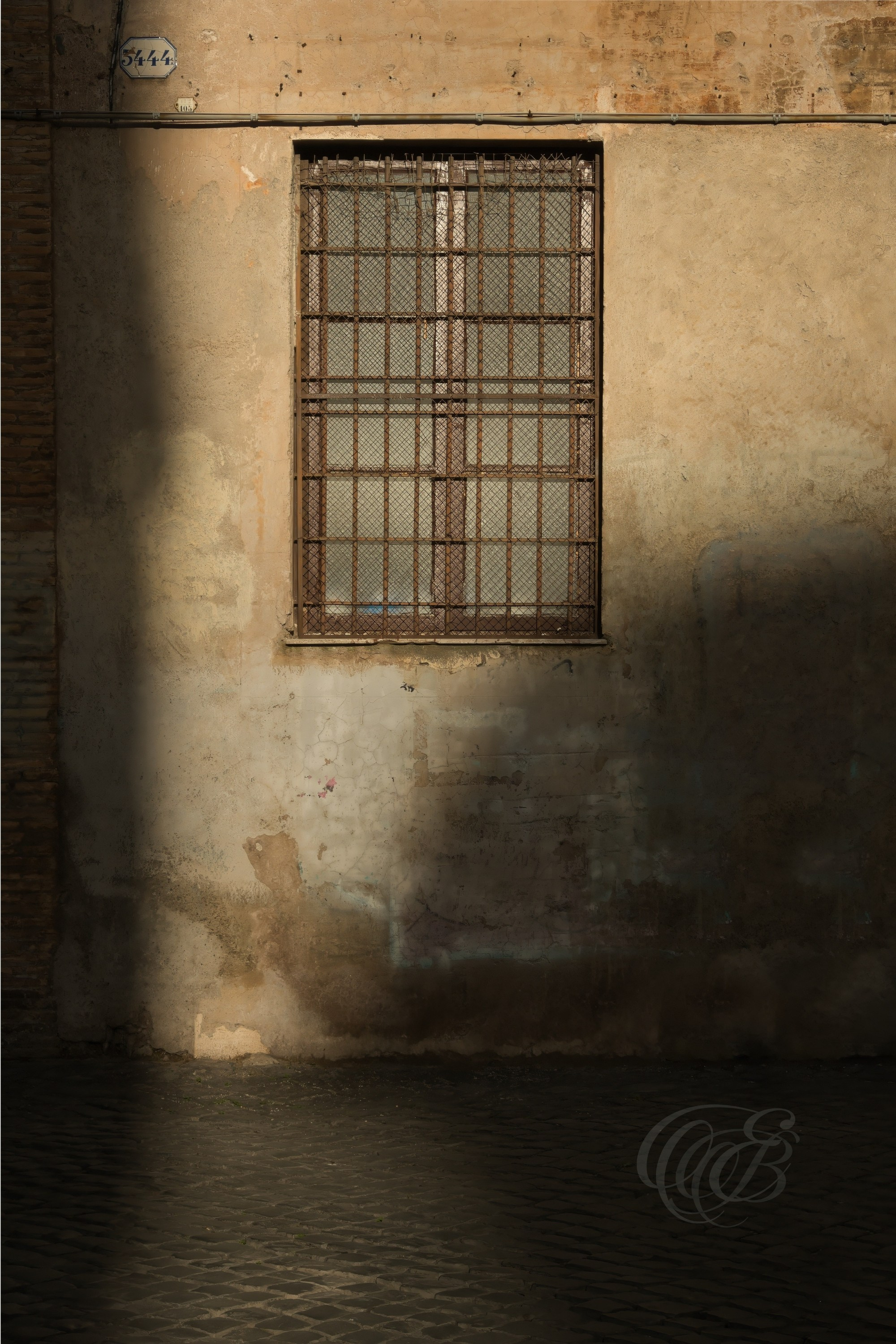 Street Photography — Rome, Italy — Partial Shade — Window partially visible between deep shadows in a dark corner of a Roman street, capturing the contrast of light and shade across the city’s architecture — Eduardo Bartoli Photography.