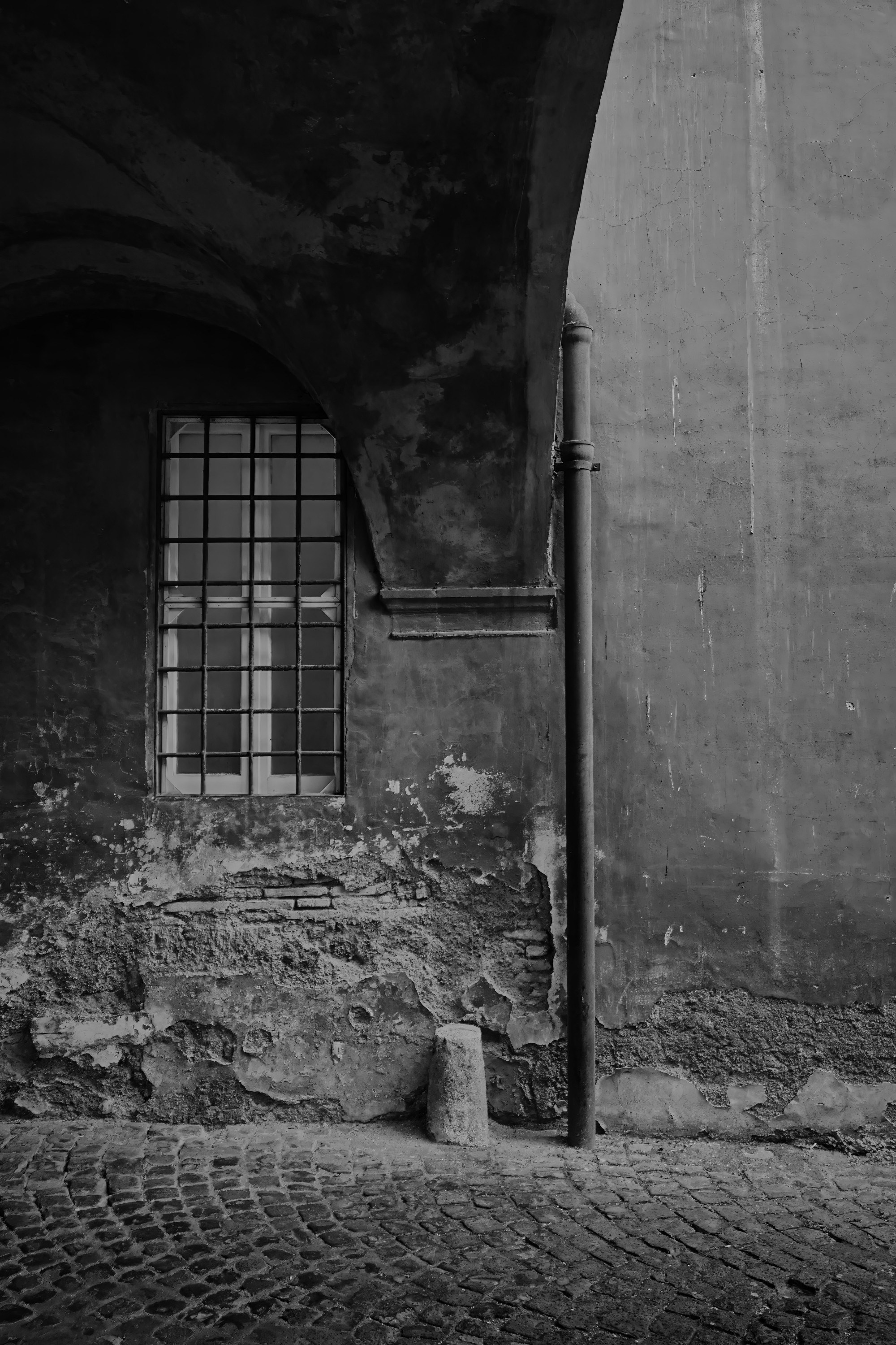 Street Photography — Rome, Italy — San Giovanni Hospital Window — B&W — Black and white study of a window within Rome’s historic San Giovanni hospital complex, emphasizing architectural details, aged surfaces, and the institutional heritage of the Lateran area — Eduardo Bartoli Photography.