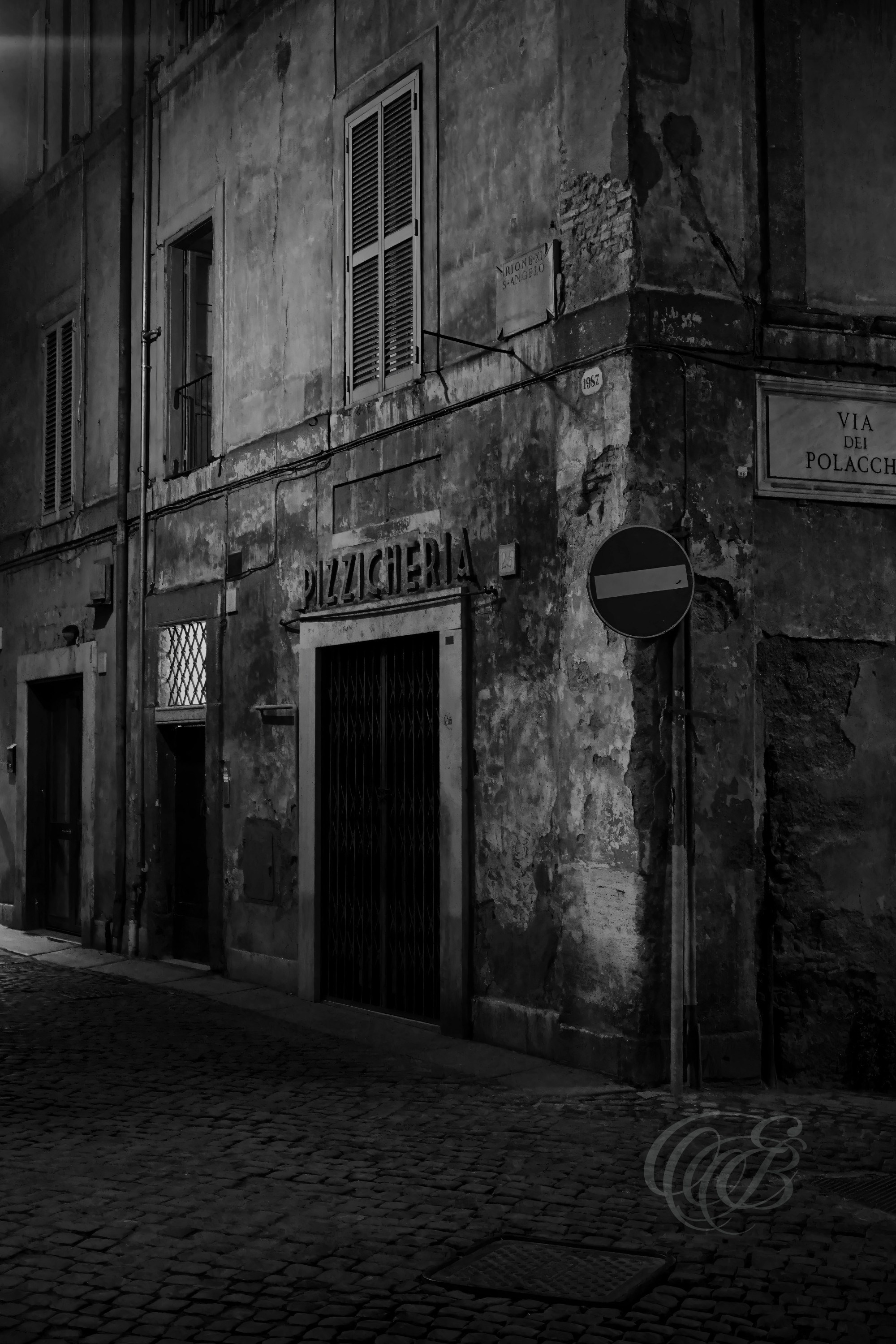Street Photography — Rome, Italy — Via dei Polacchi — B&W — Black and white view of historic Via dei Polacchi in central Rome, emphasizing traditional architecture, aged urban textures, and the cultural history preserved within the city’s streets — Eduardo Bartoli Photography.