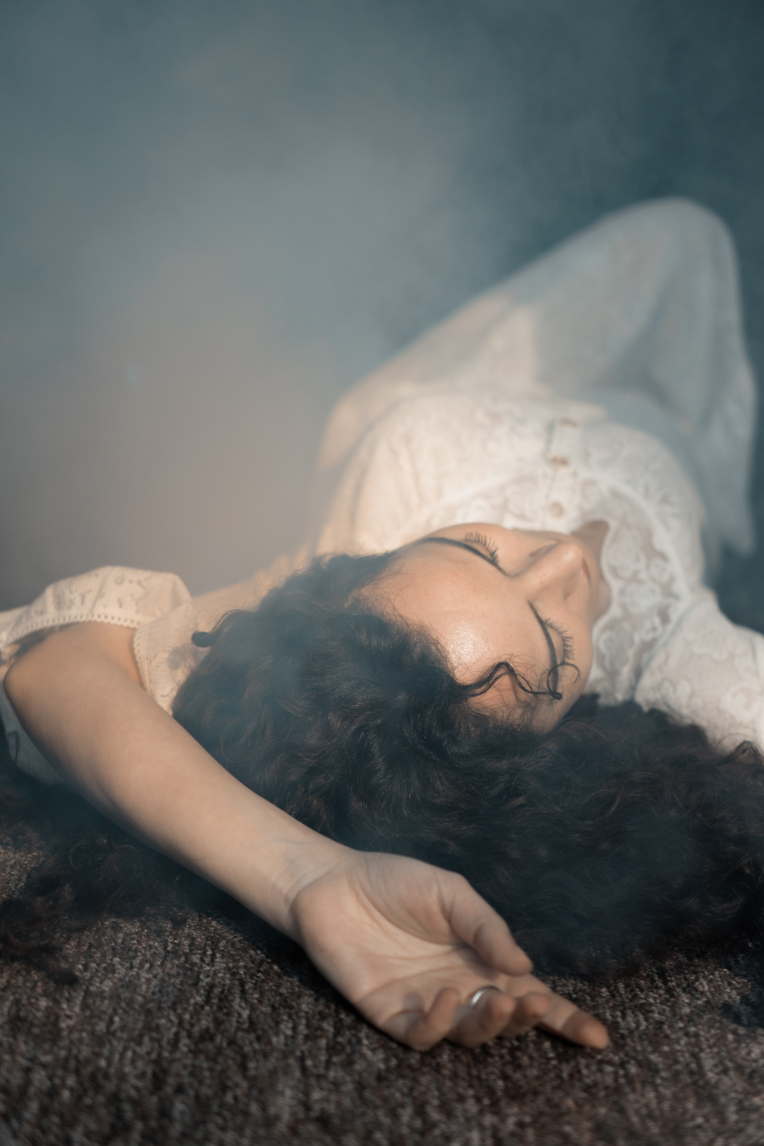 Träumerisches Portrait, Frau in Weiß liegt auf dem Boden – stimmungsvolle Fotografie