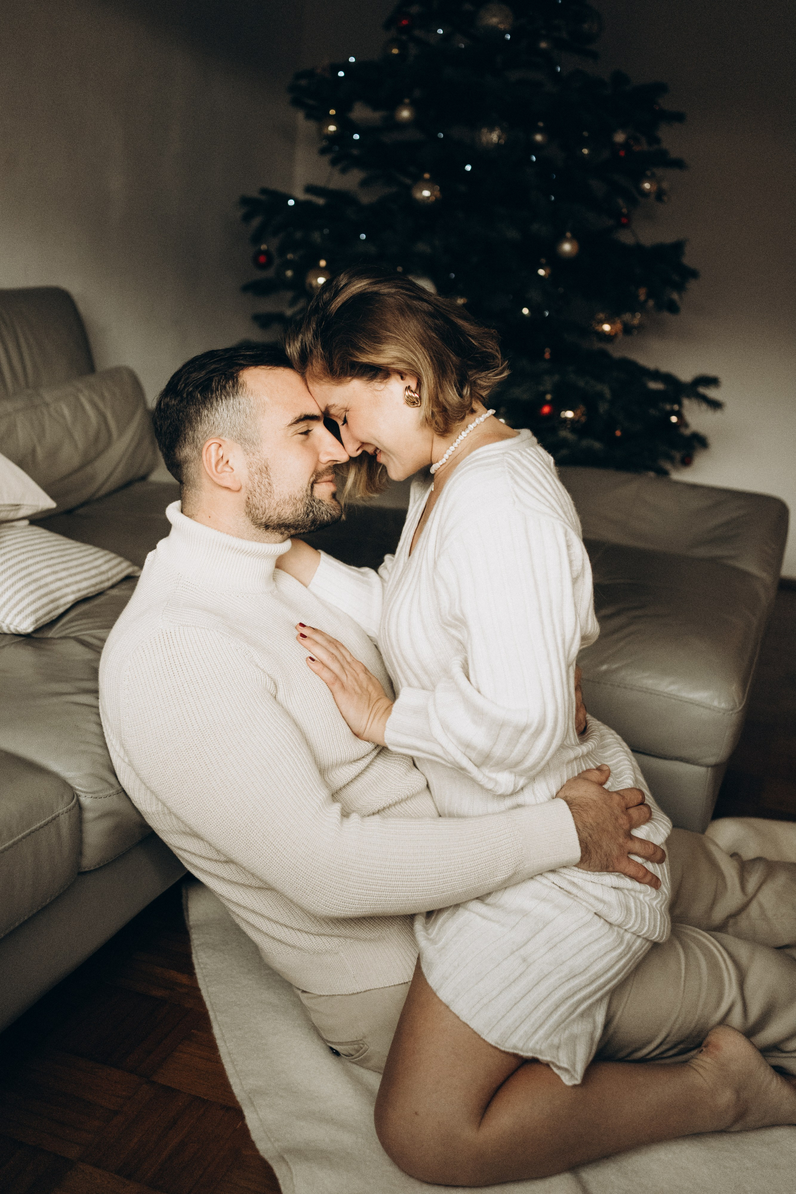 Das Paar sitzt auf dem Boden und teilt dabei liebevolle Blicke und zärtliche Berührungen.