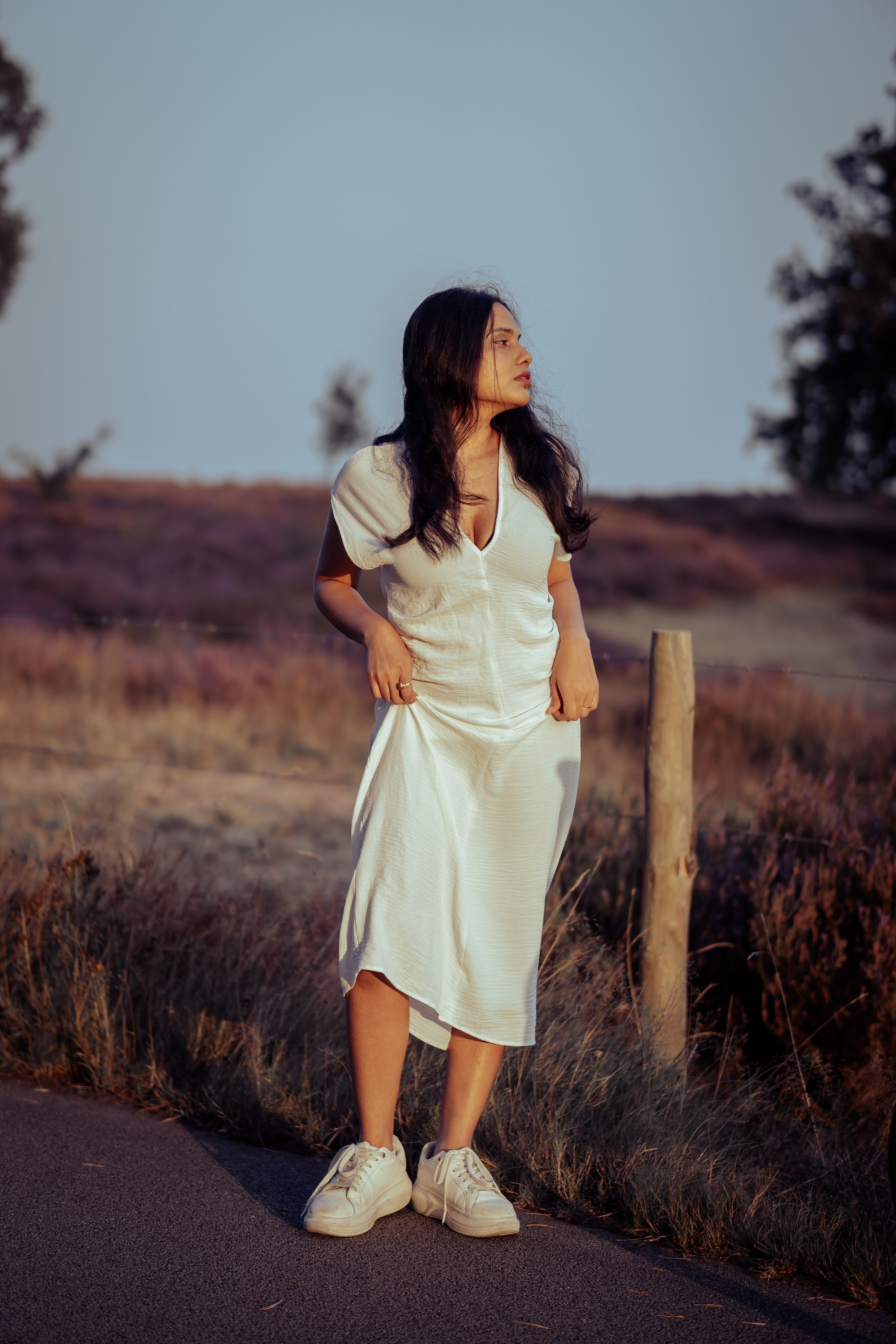 girl standing on road by heather fields in veluwe