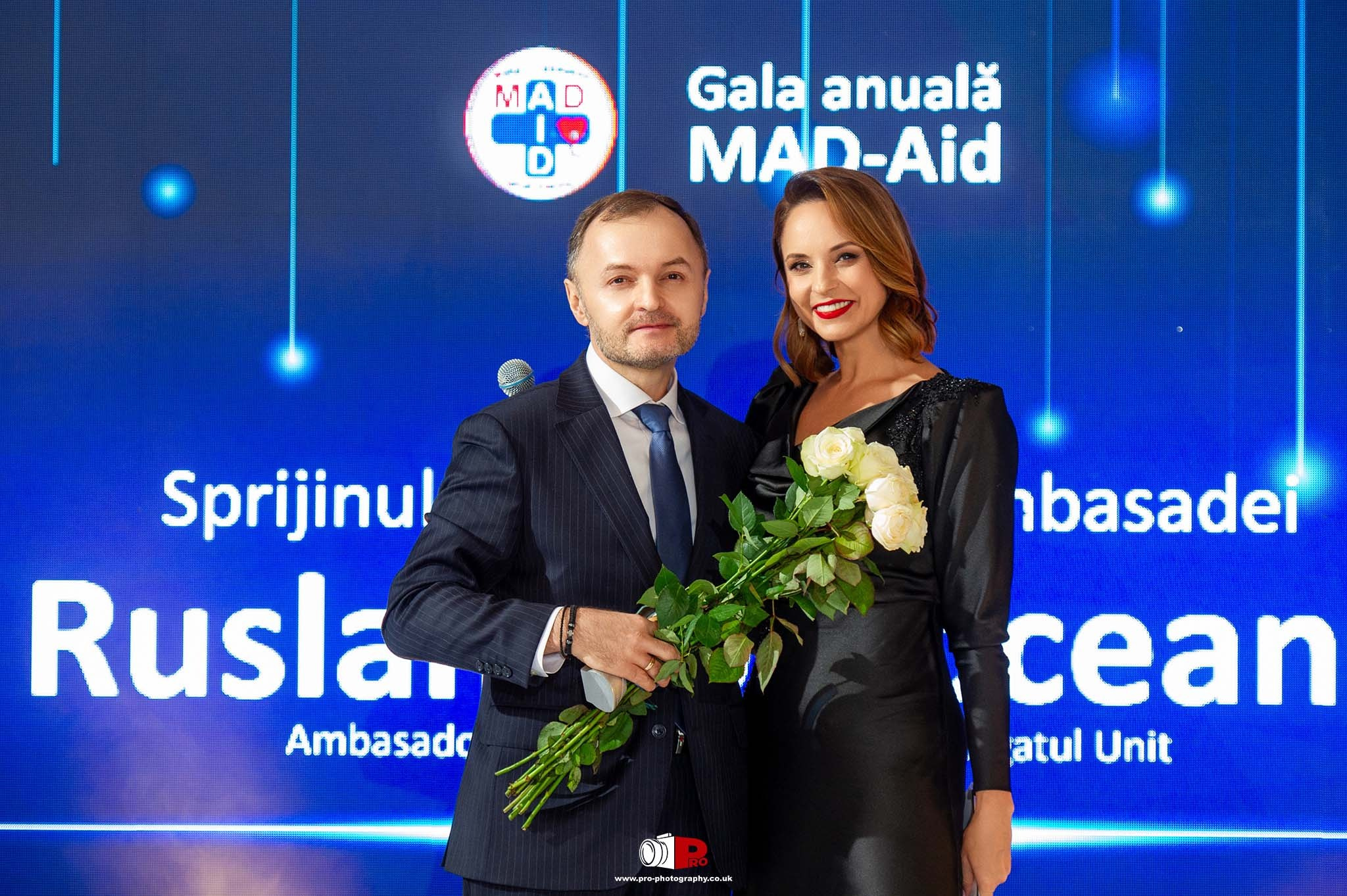 Moldavian Ambassador receiving flowers on stage during the MAD-Aid charity gala event with Andreea Marin