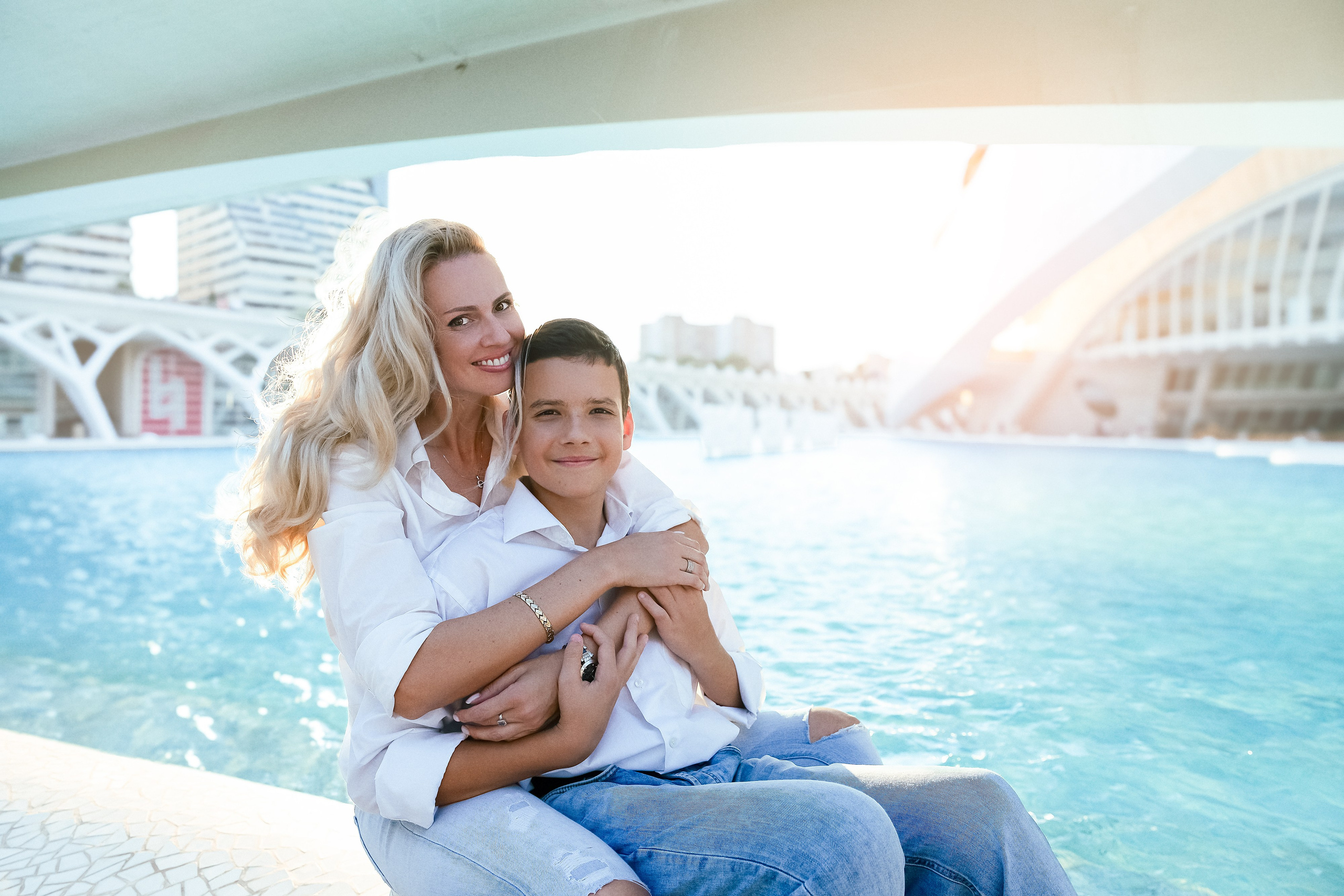 Madre e hijo sonriendo cálidamente durante una sesión familiar en Valencia, España, con la Ciudad de las Artes y las Ciencias de fondo — un ejemplo hermoso de fotografía familiar moderna y emotiva en Valencia para quienes buscan recuerdos atemporales en toda España.