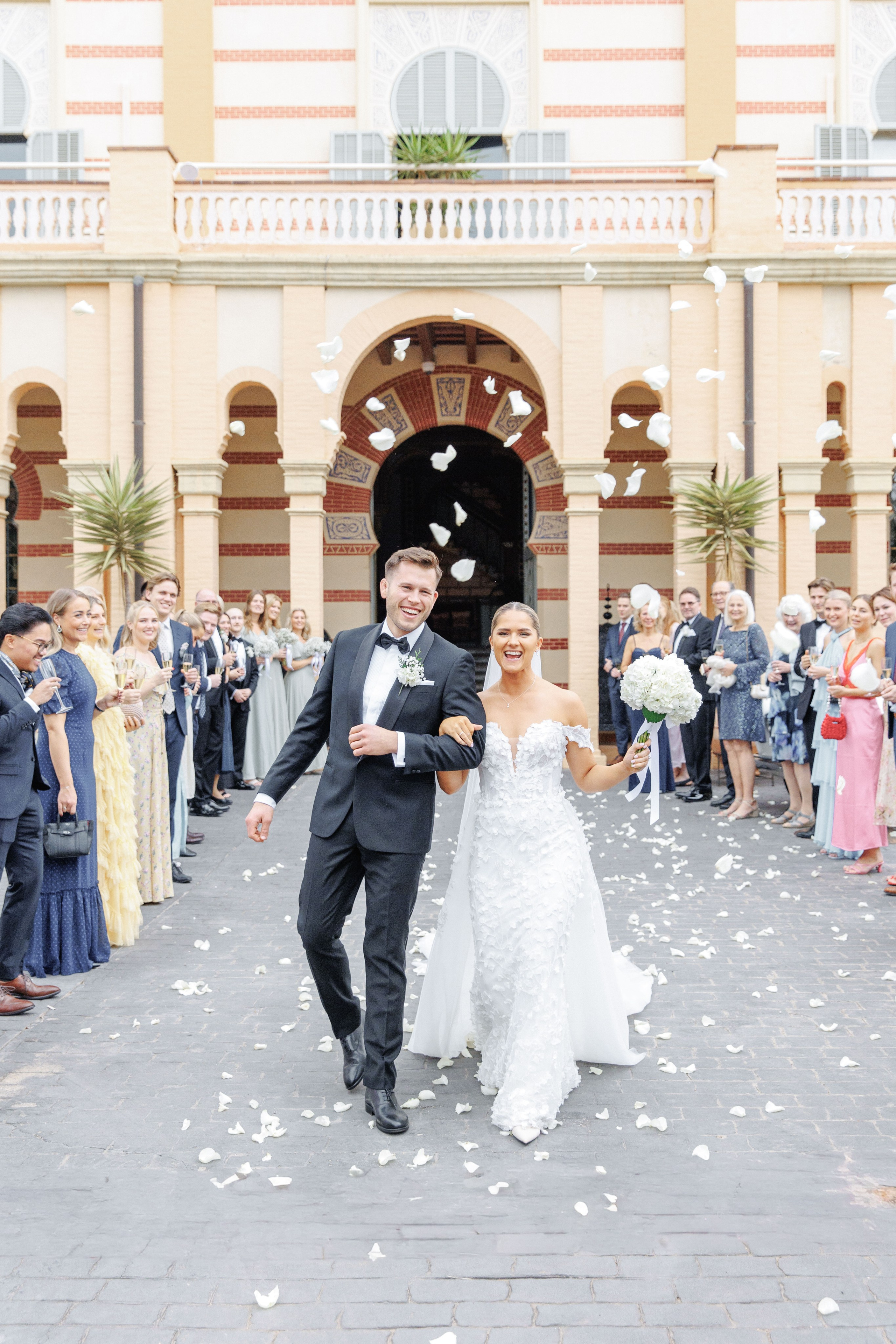 Candid shot of the bride and groom laughing with friends during the wedding celebration in Barcelona.